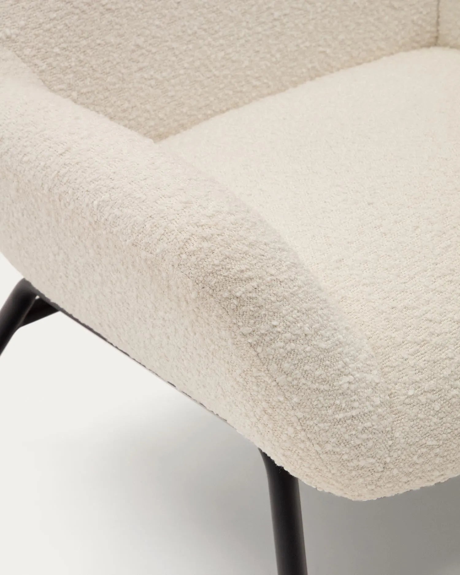 Eleganter Sessel aus weißem Bouclé mit schwarzen Stahlbeinen, FSC-zertifiziert, für stilvolle und nachhaltige Einrichtung.