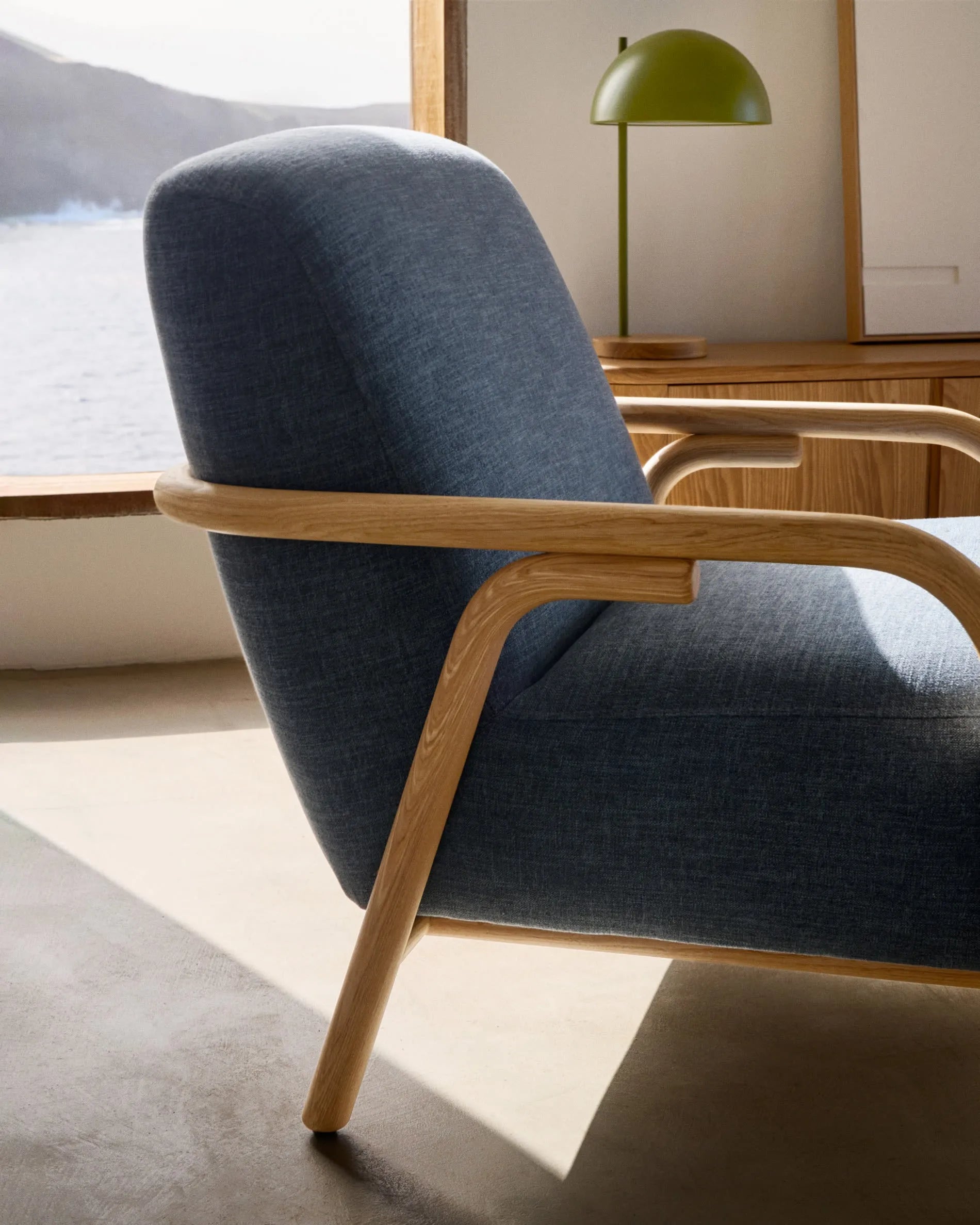 Eleganter blauer Sessel aus FSC-zertifiziertem Eschenholz, mit pflegeleichtem Baumwollbezug für stilvollen Komfort.