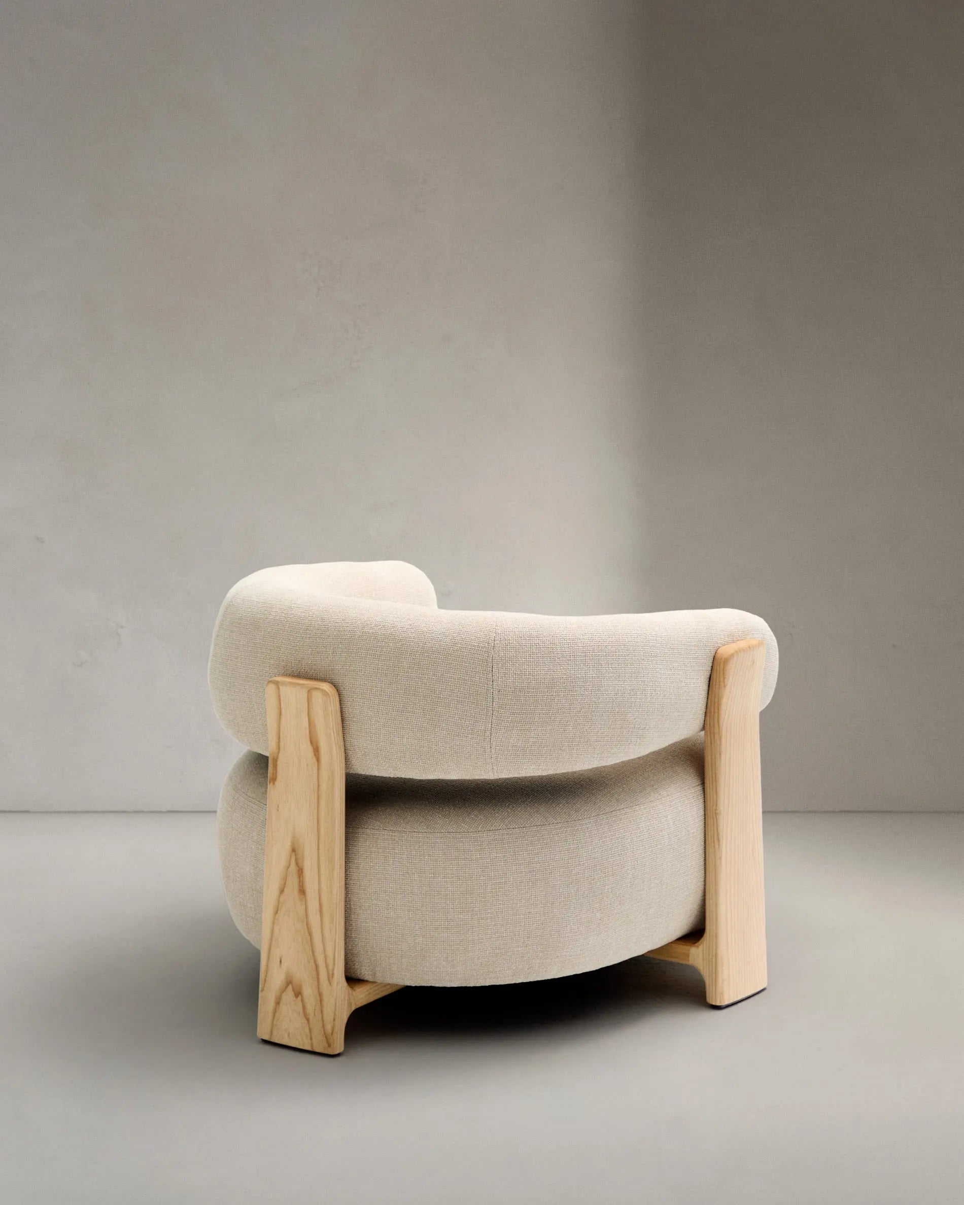 Ein eleganter Sessel mit beigefarbenem Chenille-Bezug und massiven Eschenholzbeinen, inspiriert von skandinavischem Design.
