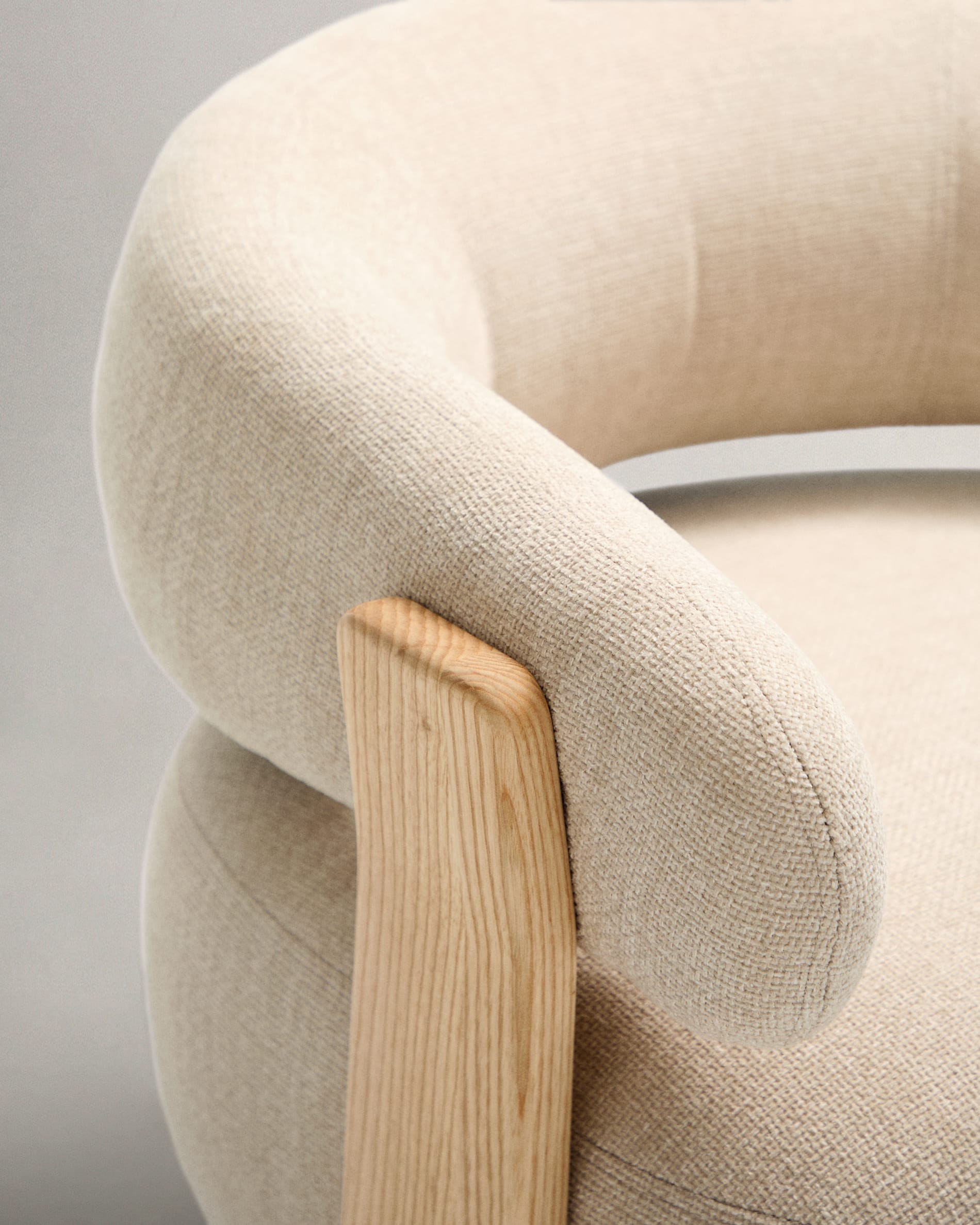 Komfortabler Sessel mit beigefarbener Chenille und FSC-zertifizierten Eschenholzbeinen, perfekt für moderne Wohnräume.