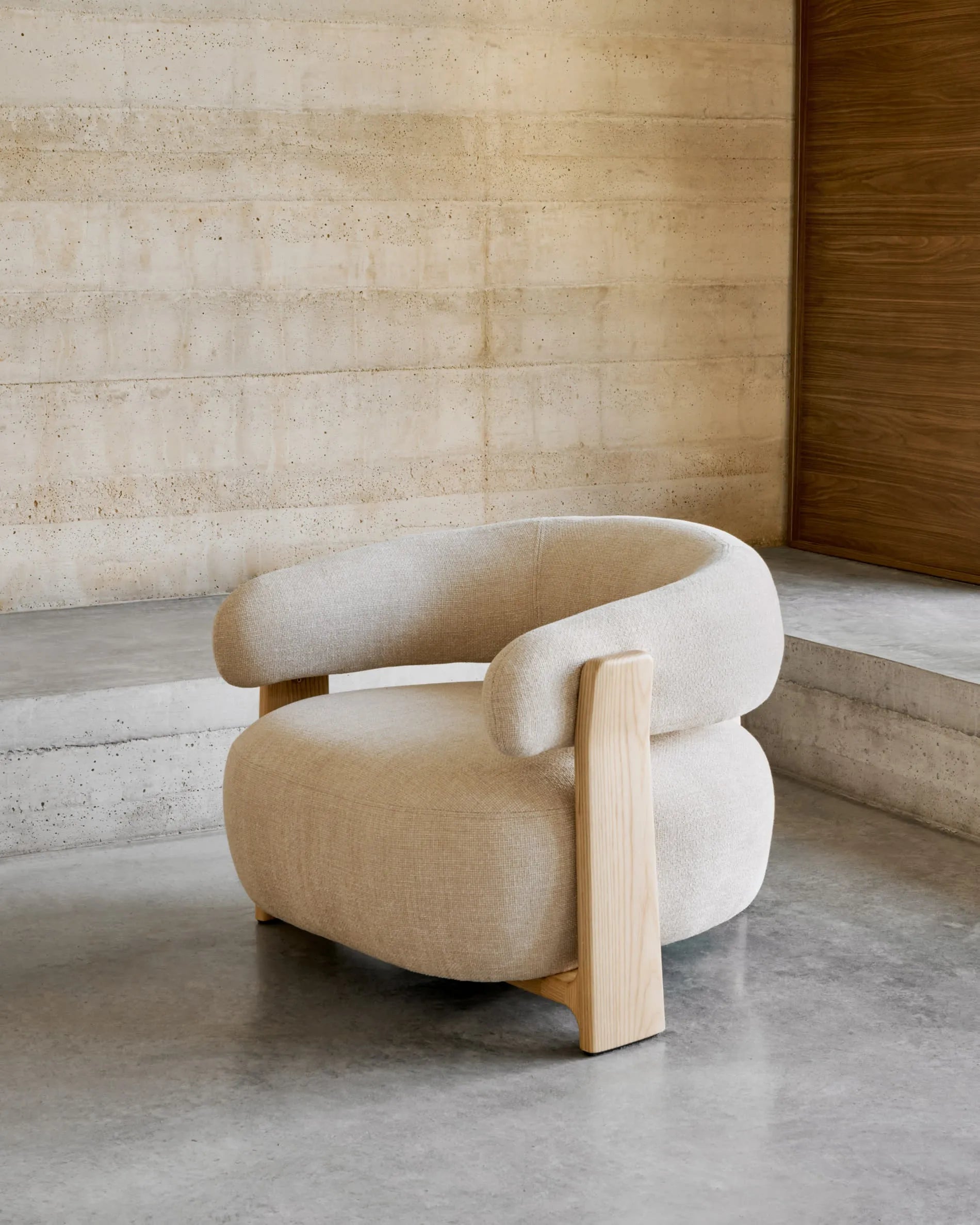 Ein eleganter Sessel mit beigefarbenem Chenille-Bezug und massiven Eschenholzbeinen, inspiriert von skandinavischem Design.