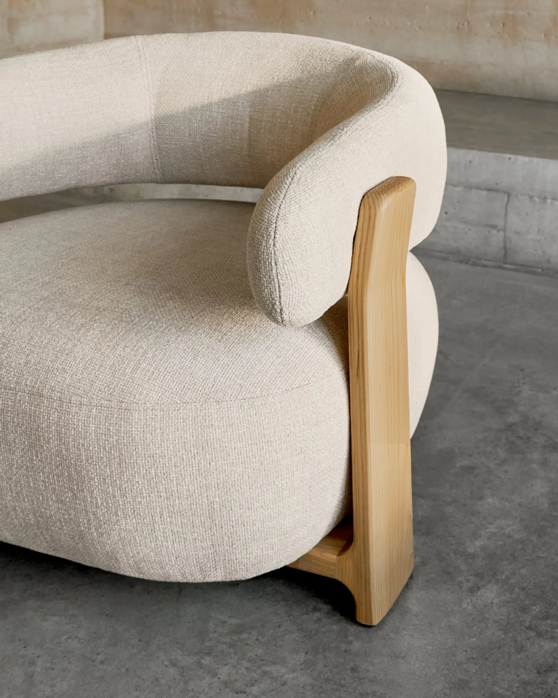 Ein eleganter Sessel mit beigefarbenem Chenille-Bezug und massiven Eschenholzbeinen, inspiriert von skandinavischem Design.