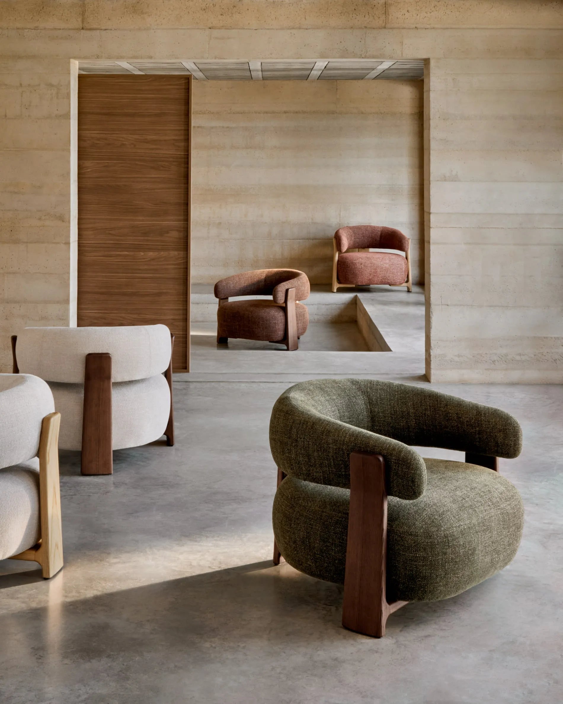 Ein eleganter Sessel mit beigefarbenem Chenille-Bezug und massiven Eschenholzbeinen, inspiriert von skandinavischem Design.