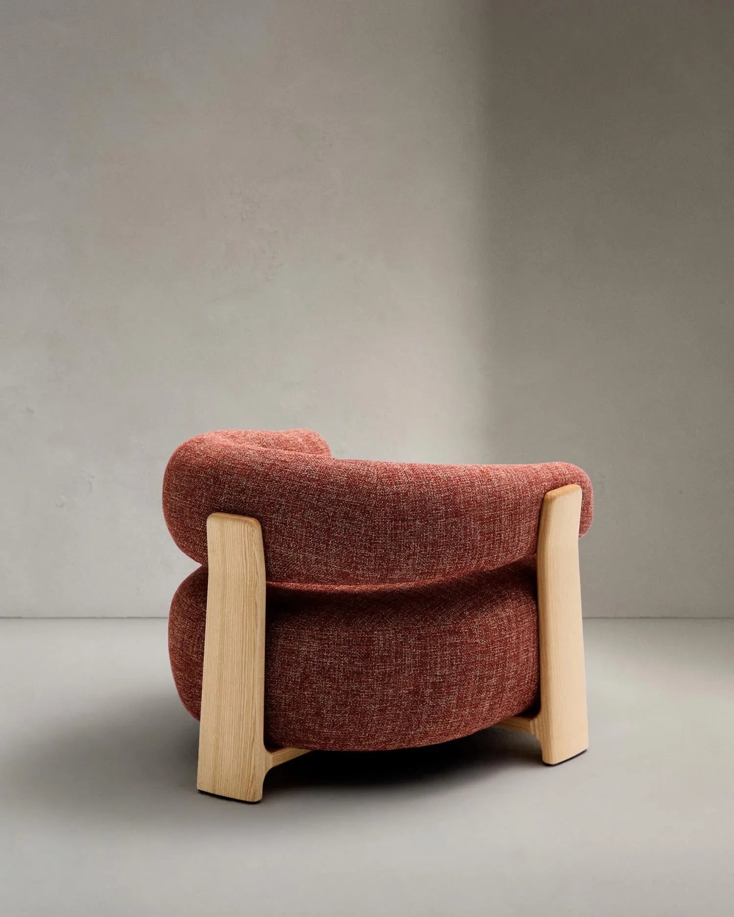 Ein stilvoller Sessel in warmem Terrakotta, inspiriert vom skandinavischen Design der 70er, mit robusten Eschenholzbeinen.