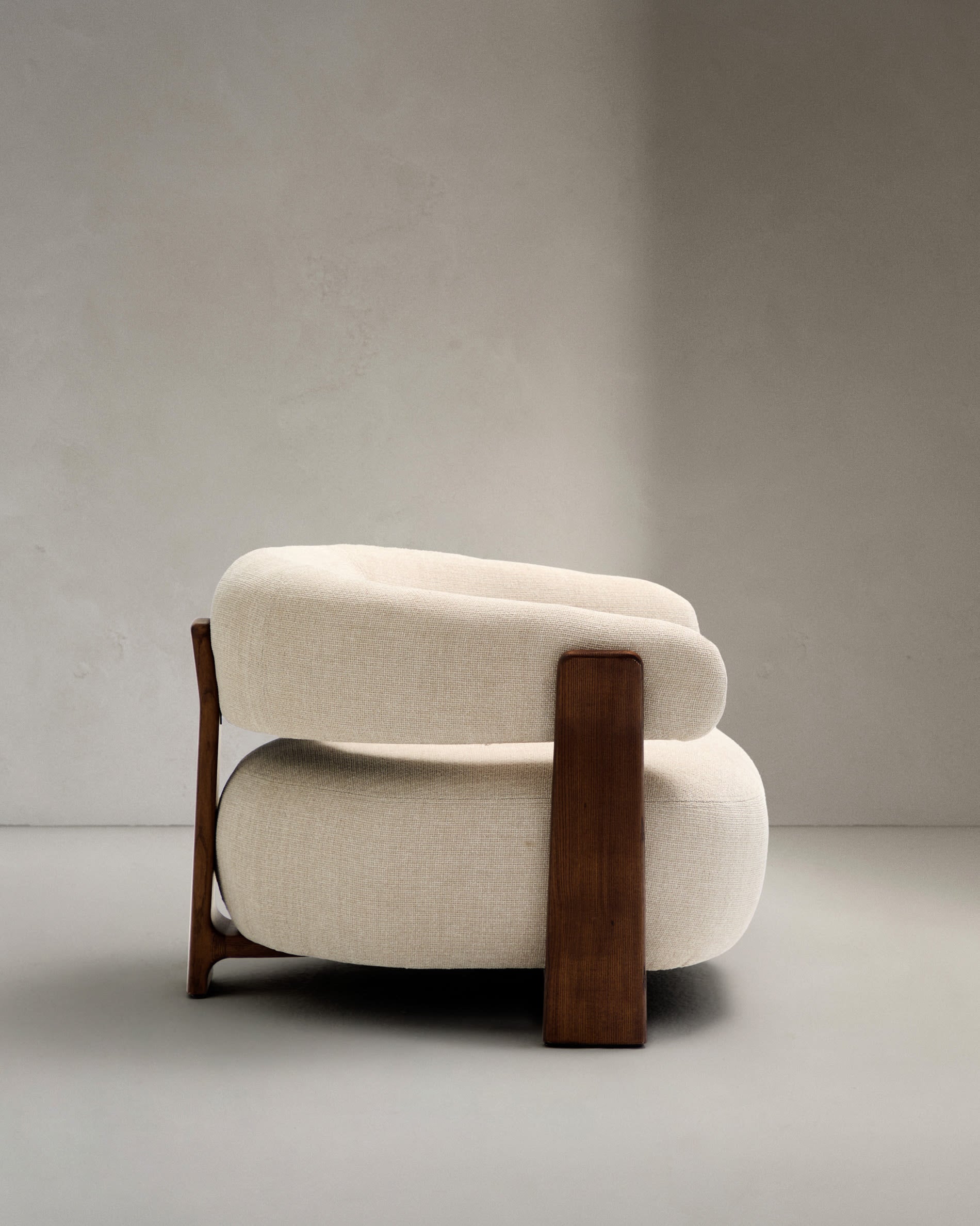 Moderner Sessel aus beiger Chenille, FSC-zertifizierte Eschenholzbeine mit Walnuss-Finish, stilvoll und umweltfreundlich.