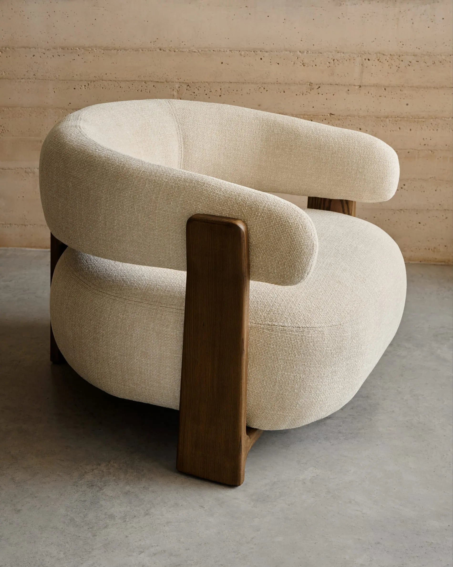 Eleganter Sessel aus beiger Chenille, Beine aus FSC-zertifiziertem Eschenholz mit Walnuss-Finish, modern und nachhaltig.