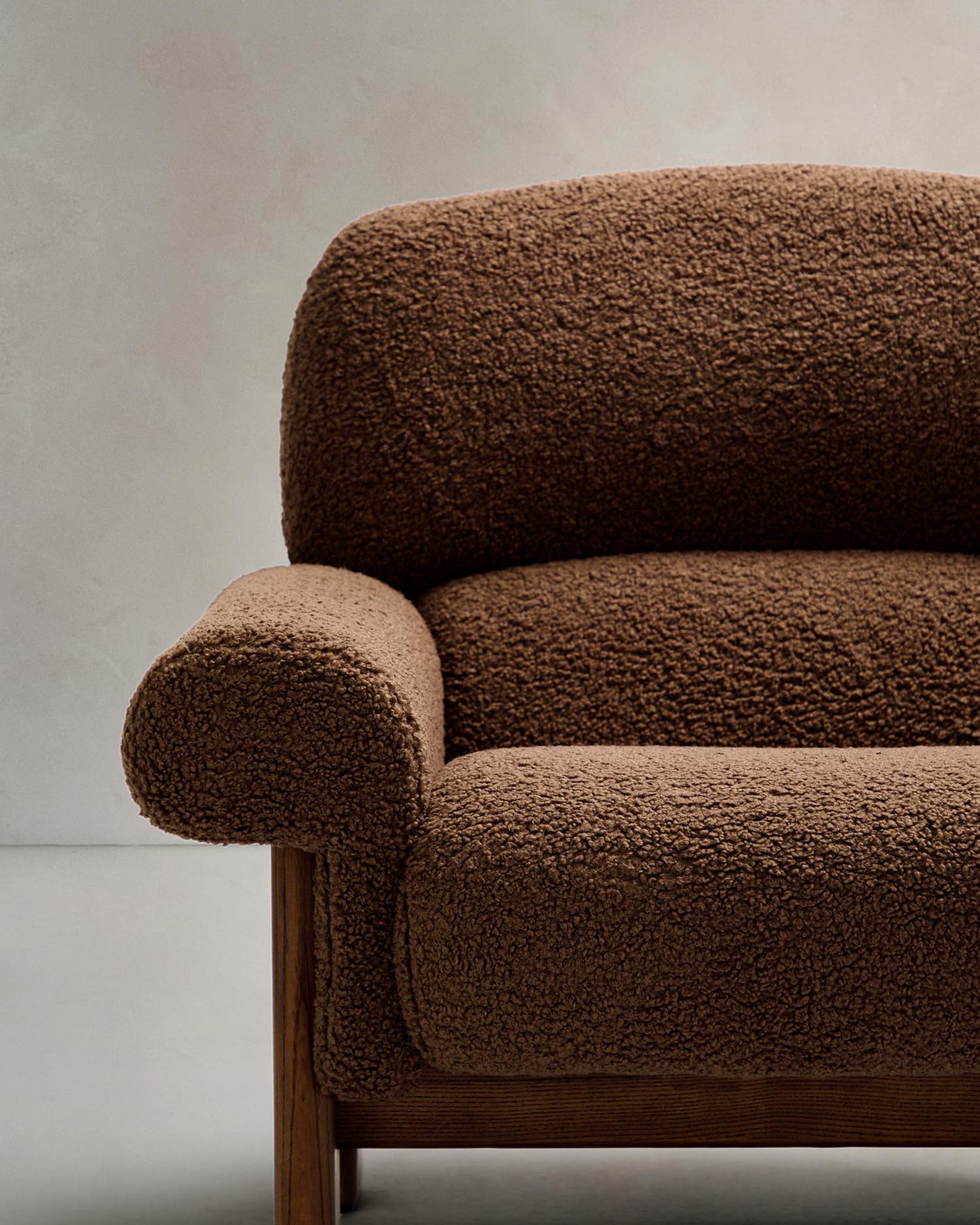 Eleganter Sessel Nema aus taupefarbenem Bouclé und FSC-zertifiziertem Eschenholz mit natürlichem Finish, perfekt für stilvolles Wohnen.