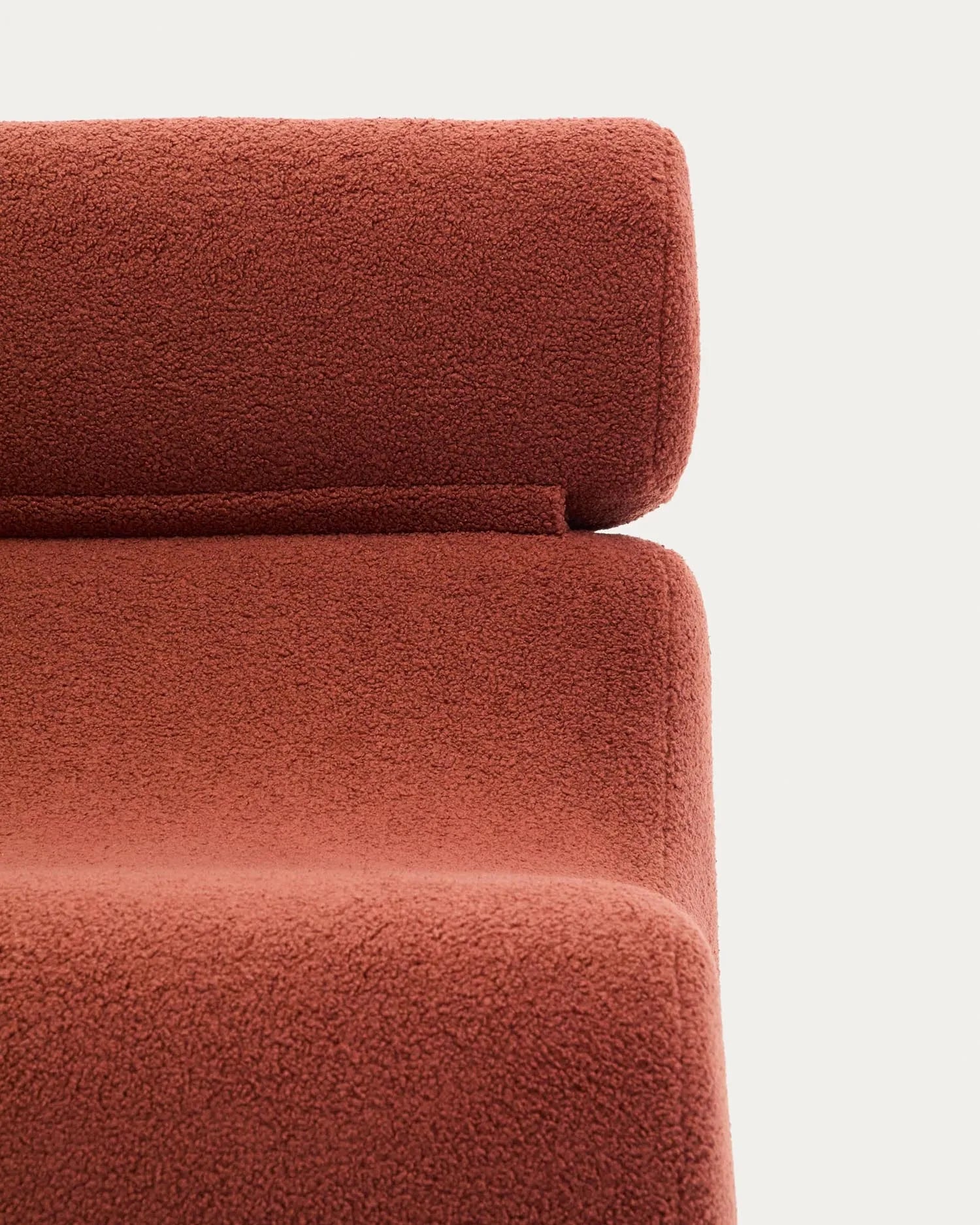 Eleganter Sessel in Terrakotta-Bouclé, vereint Komfort und Stil mit klappbarer Kopfstütze und nachhaltigen Materialien.