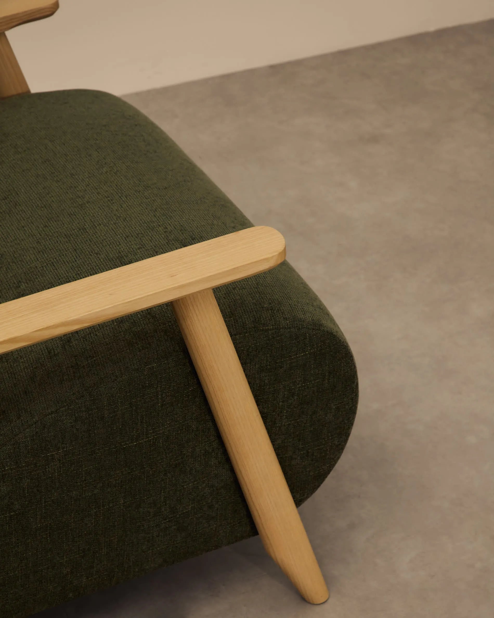 Eleganter Sessel aus grünem Chenille und Eschenholz, FSC-zertifiziert, bietet Komfort und Stil für jeden Raum.
