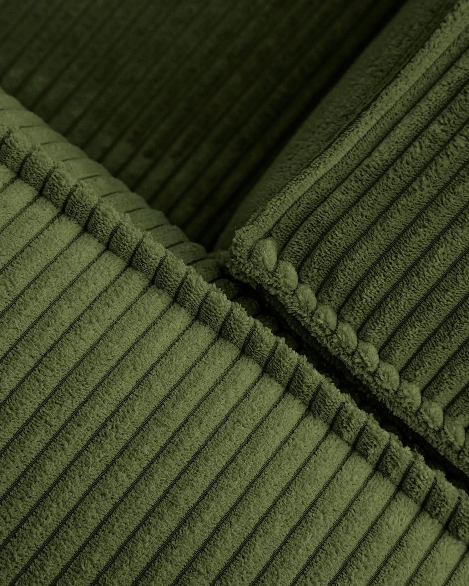 Das grüne Blok 5-Sitzer-Ecksofa aus breitem Cord (320x290 cm) von Kave Home vereint Komfort und nachhaltiges Design.