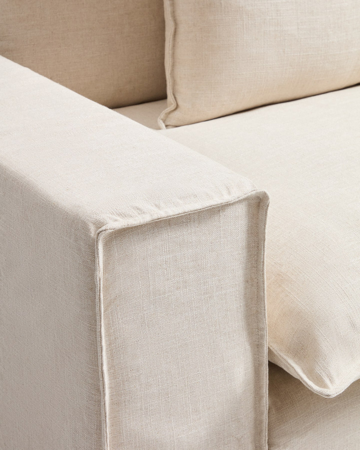 Sessel Anarela in Beige mit abnehmbarem Bezug aus Leinen und Viskose, schwarze Beine aus Polypropylen, Breite 130 cm.