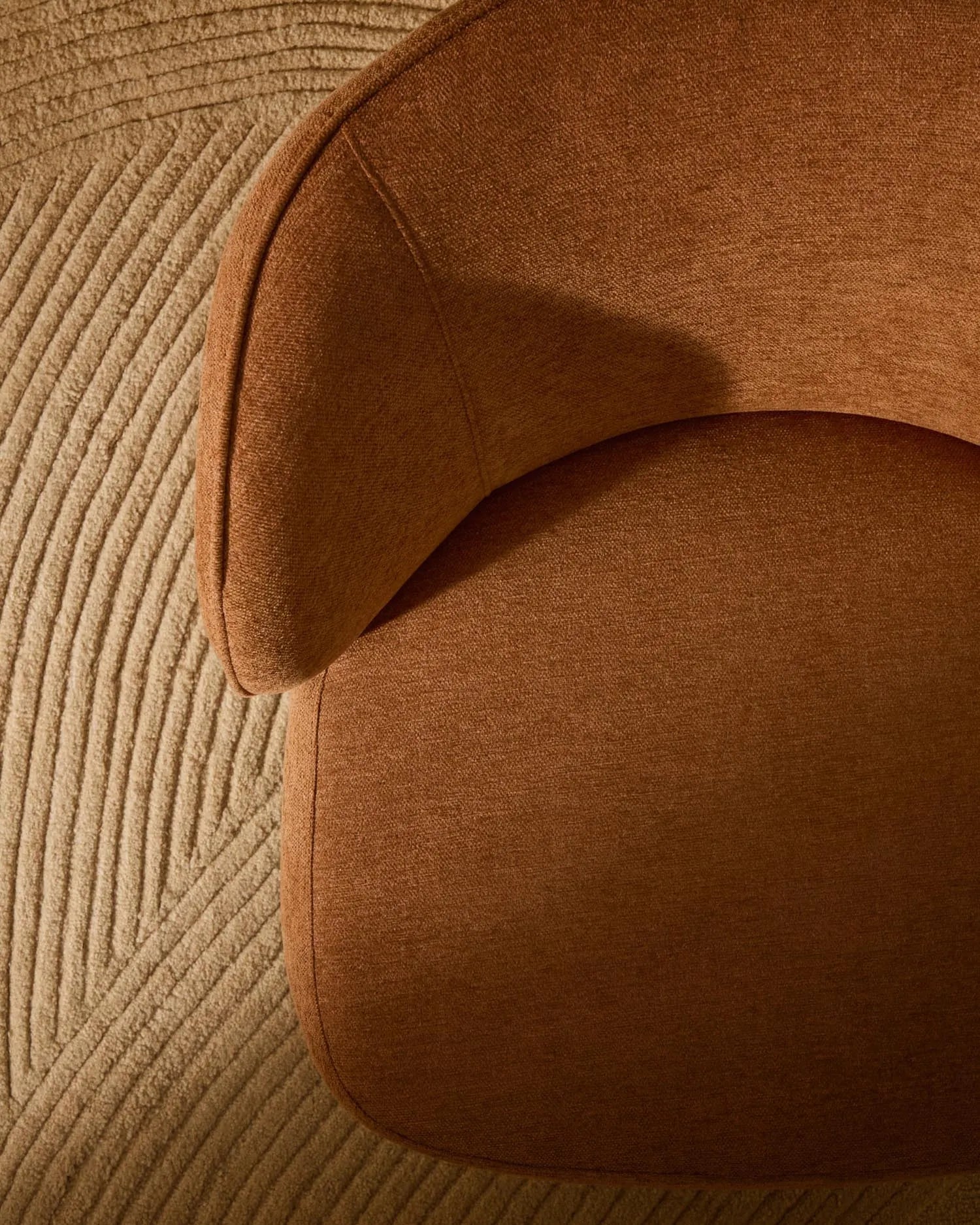 Der Sessel Ulit besticht durch terrakottafarbene Chenille und elegante Buchenholzbeine, ideal für stilvolle Entspannung.