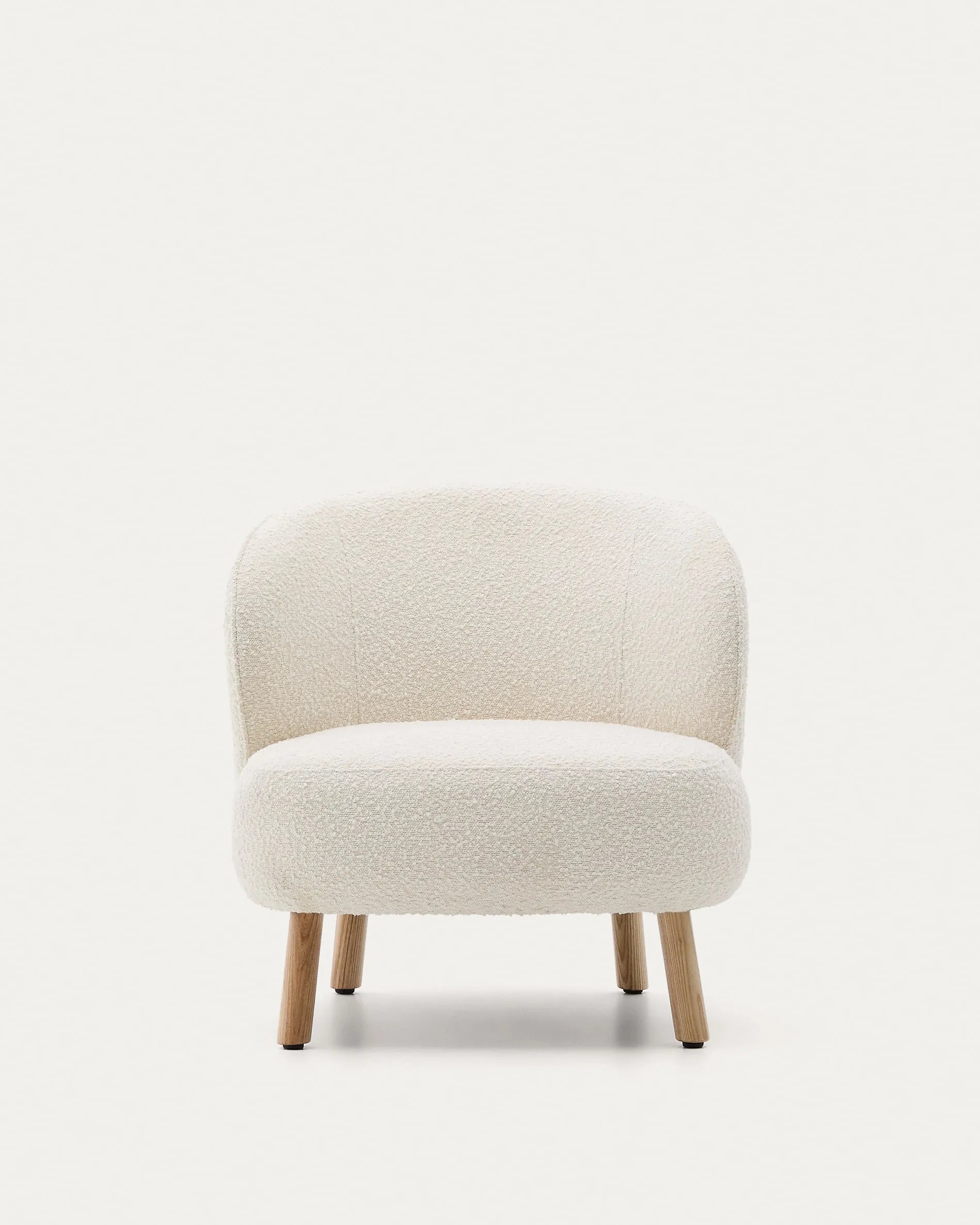 Eleganter Sessel mit weißem Schaffellbezug und stabilen Buchenholzbeinen, ideal für stilvolle, kompakte Räume.