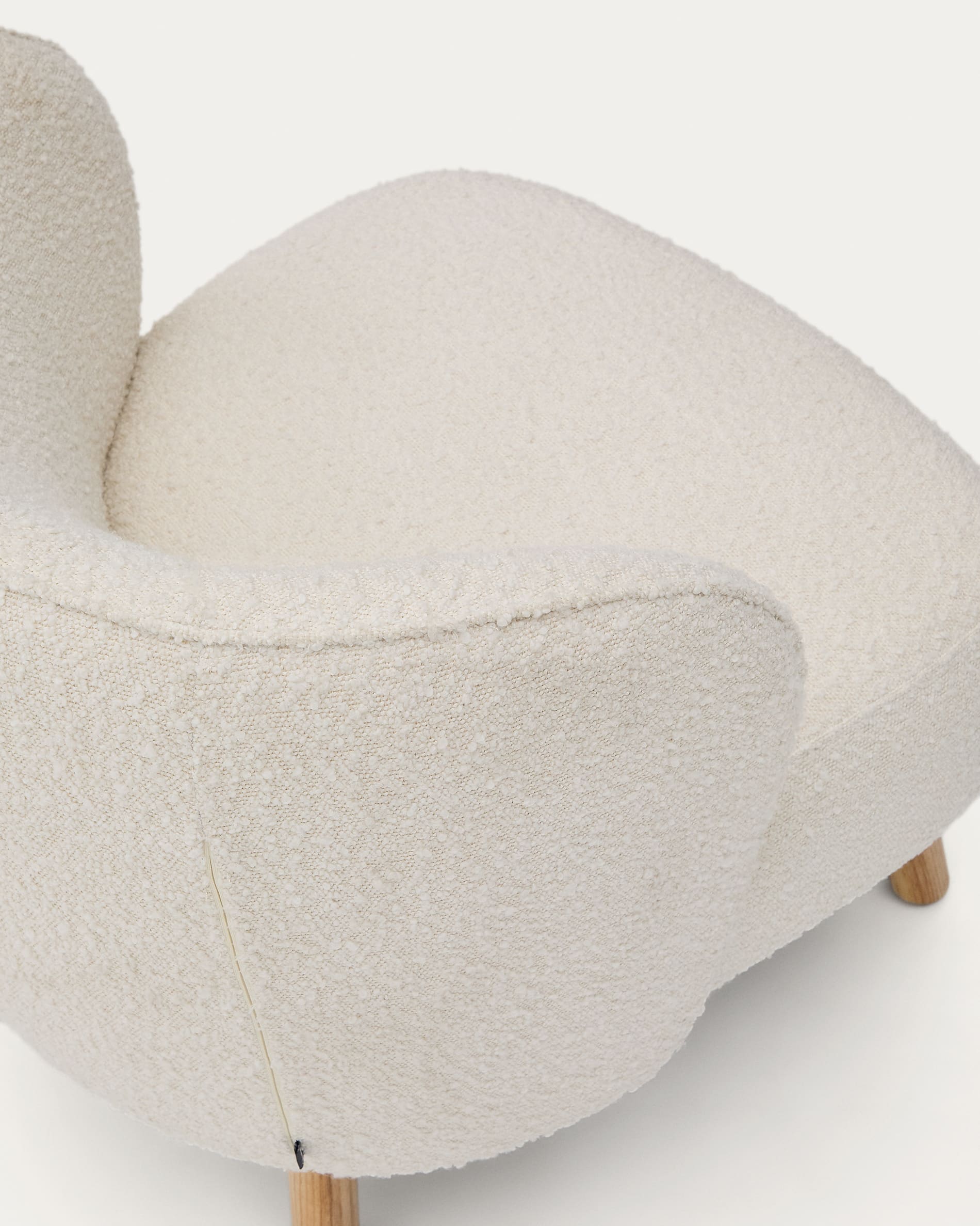 Sessel Ulit: Elegantes Design mit weißem Schaffell und robusten Buchenholzbeinen, natürlich veredelt. Ideal für modernes Wohnen.