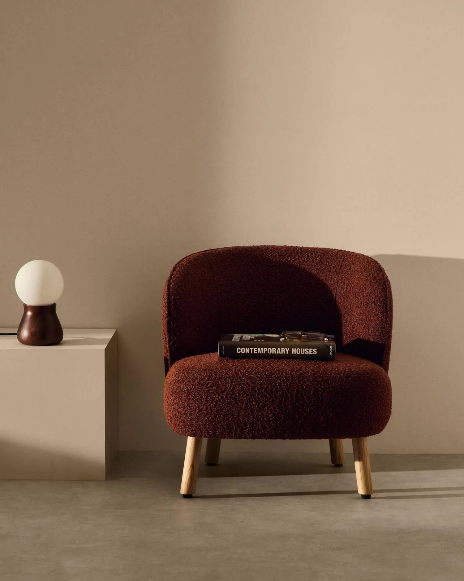 Sessel Ulit: Terrakottafarbenes Schaffell, Beine aus massivem Buchenholz mit natürlichem Finish, elegant und gemütlich.