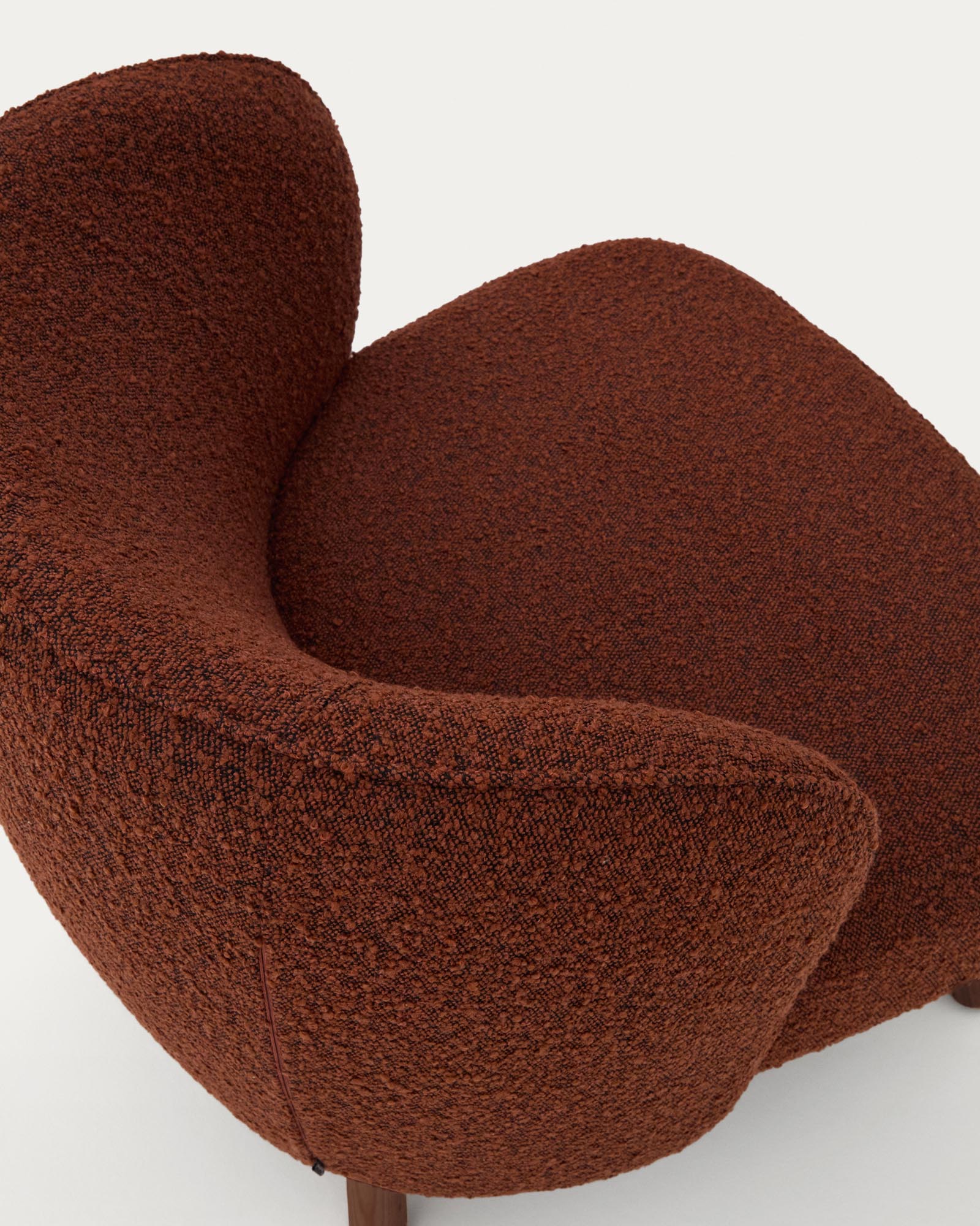 Eleganter Sessel Ulit in warmem Terrakotta-Look aus Lammfellimitat, mit stabilen Eschenholzbeinen in luxuriösem Nussbaum-Finish.