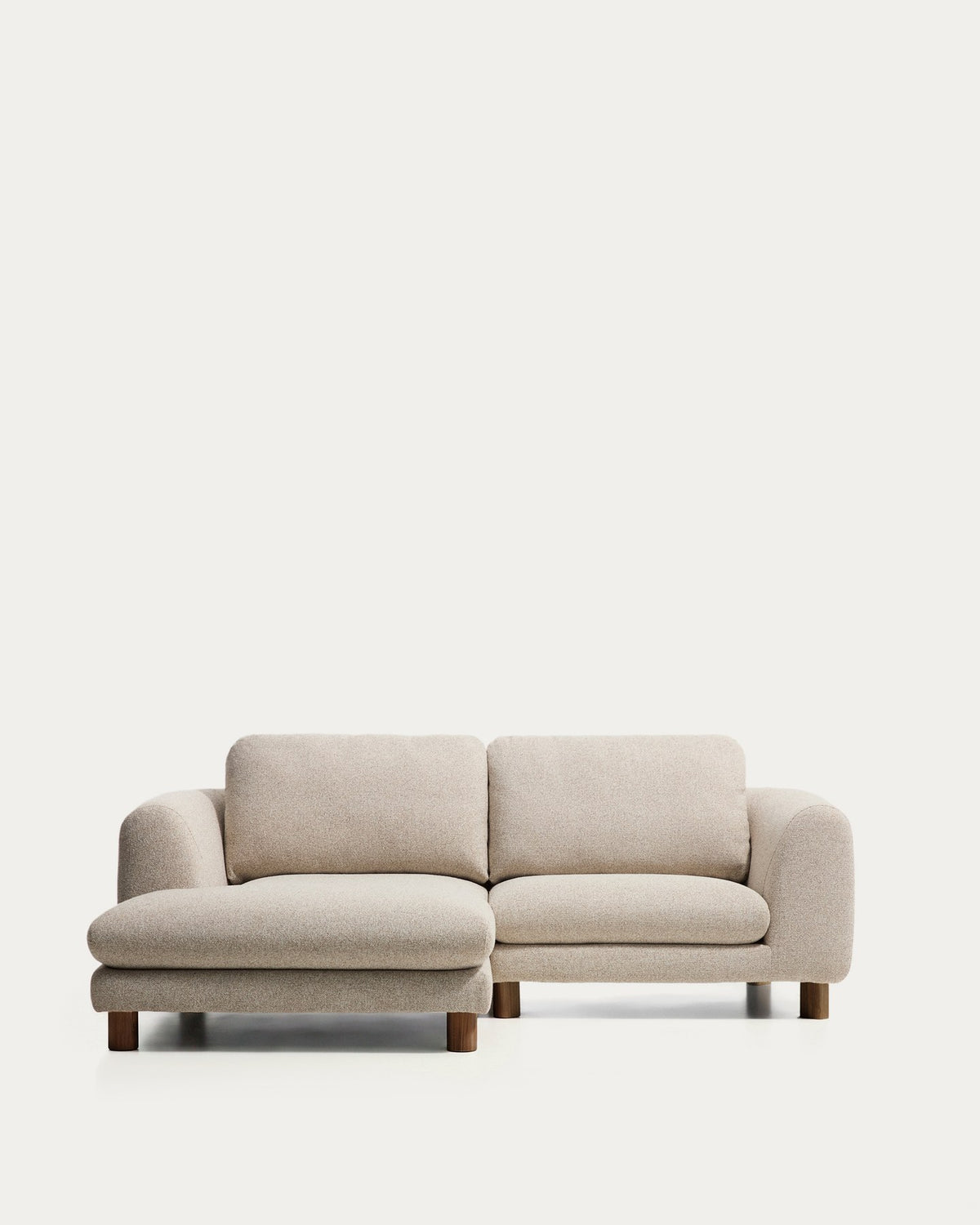 3-Sitzer Sofa Vera in Beige mit Chaiselongue links, gepolsterten Armlehnen und sichtbaren Beinen aus massivem Eschenholz mit Nussbaum-Finish.