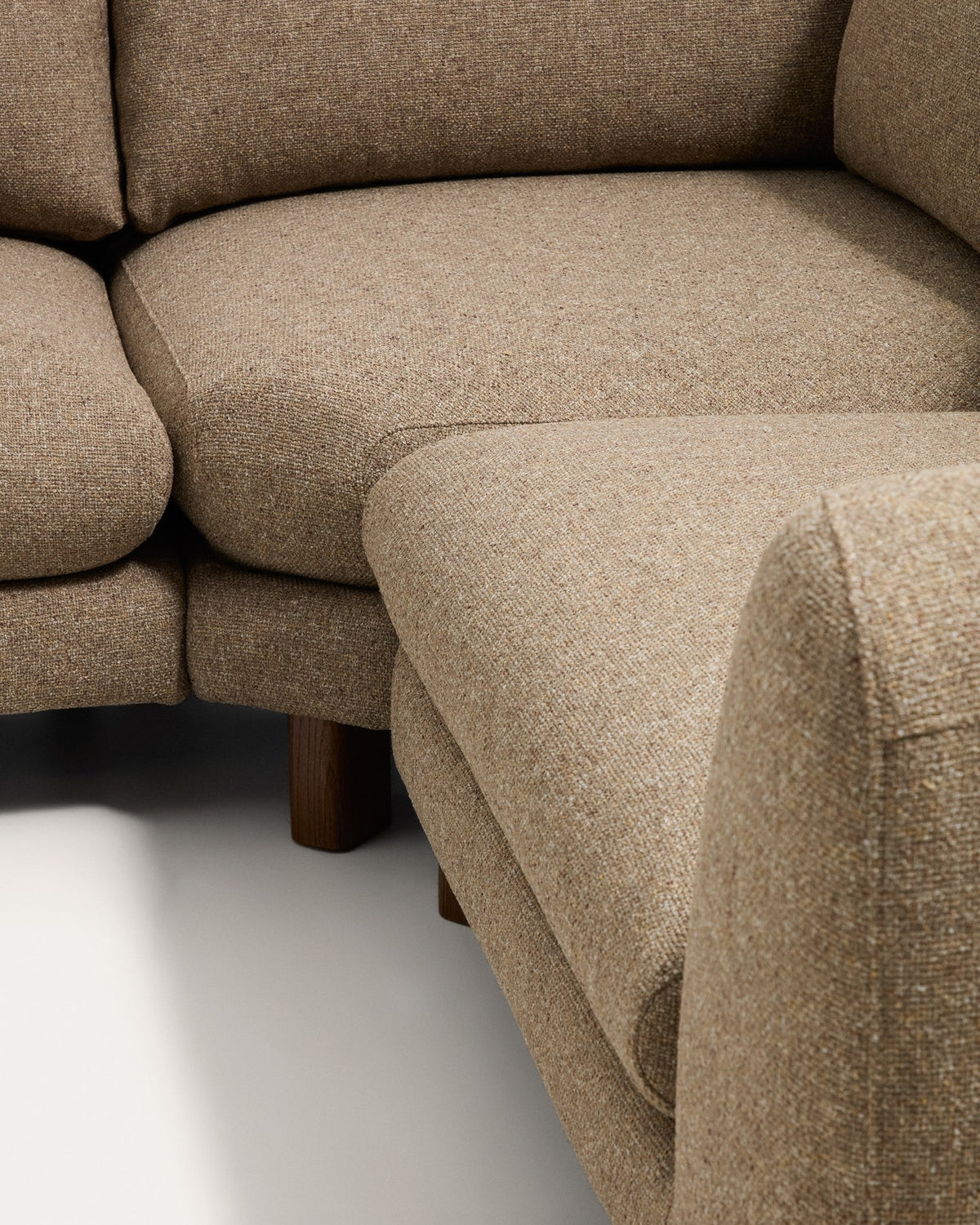 5-Sitzer Ecksofa Vera von Kave Home in Hellbraun mit Stoffbezug, geschwungenen Armlehnen und Beinen aus Eschenholz mit Nussbaum-Finish.