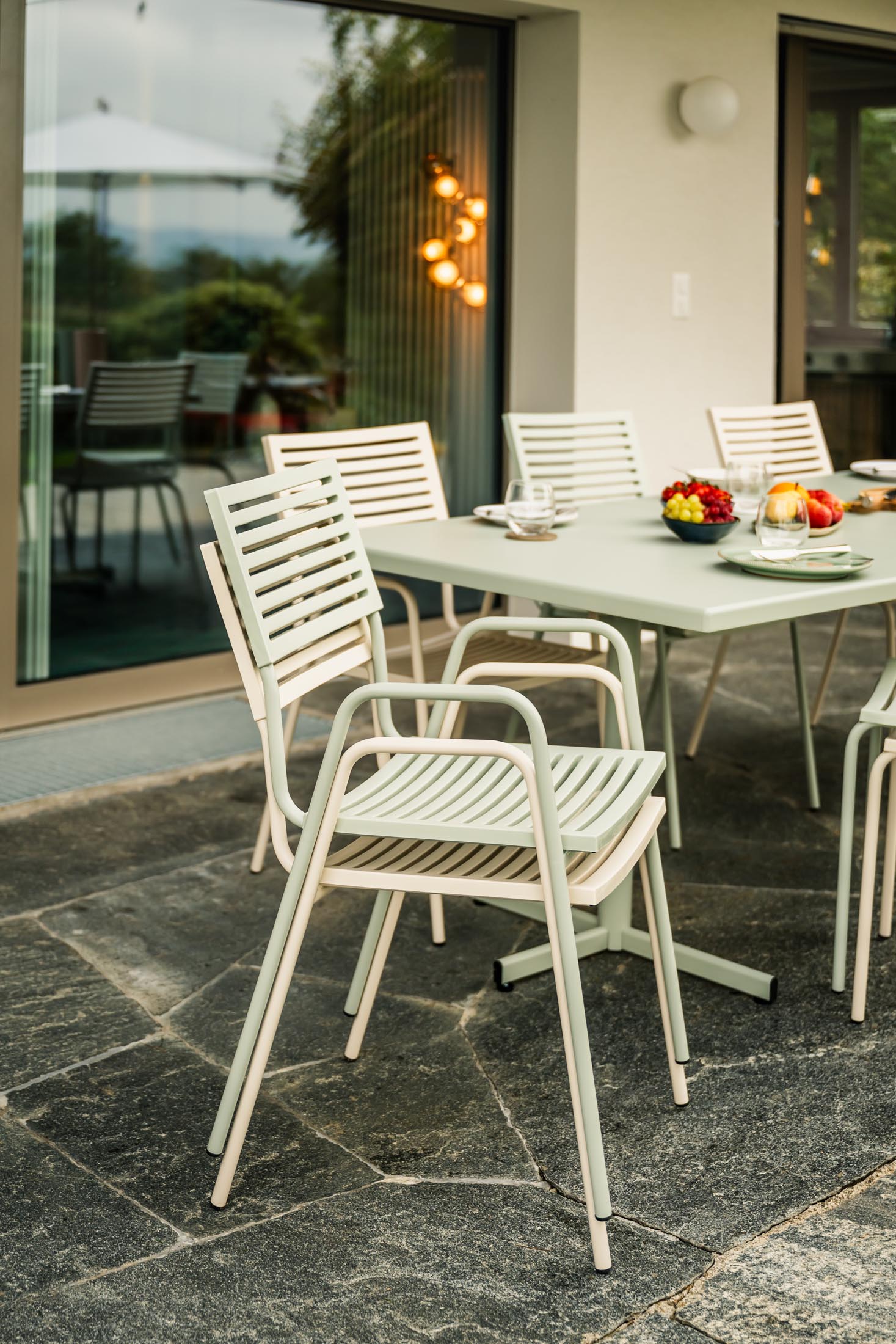 Eleganter, wetterfester Bodensee Lamello-Gartenstuhl mit Armlehne von Schaffner. Hochwertige Schweizer Handwerkskunst, UV-beständig, langlebig und pflegeleicht für den Außenbereich.