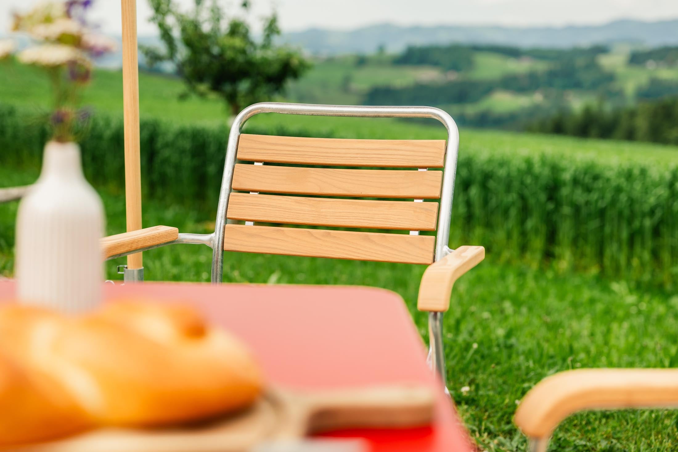 Schaffner Rigi Holzlatten-Gartenstuhl mit Armlehne aus robustem Eschenholz, wetterfest, elegant, langlebig, Schweizer Qualität, ideal für Garten und Terrasse.
