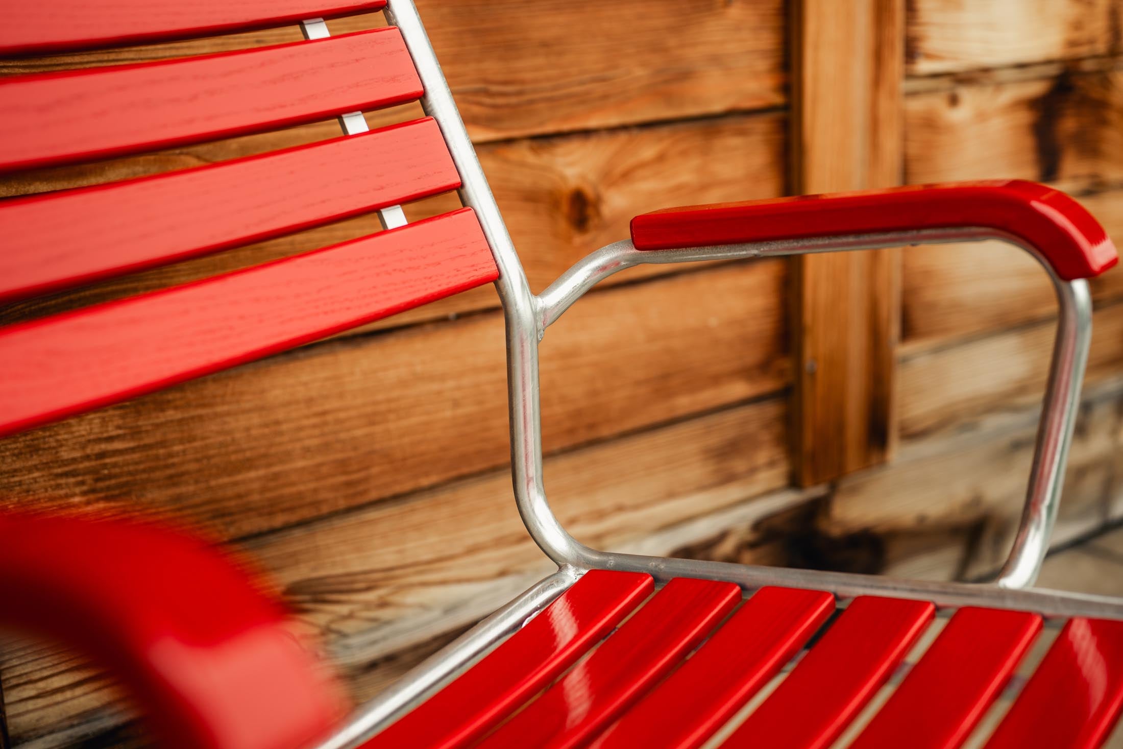 Entdecken Sie den langlebigen Rigi Holzlatten-Salonsessel mit Armlehne aus Schweizer Eschenholz – wetterfest, bequem und elegantes Design für Ihren Außenbereich.