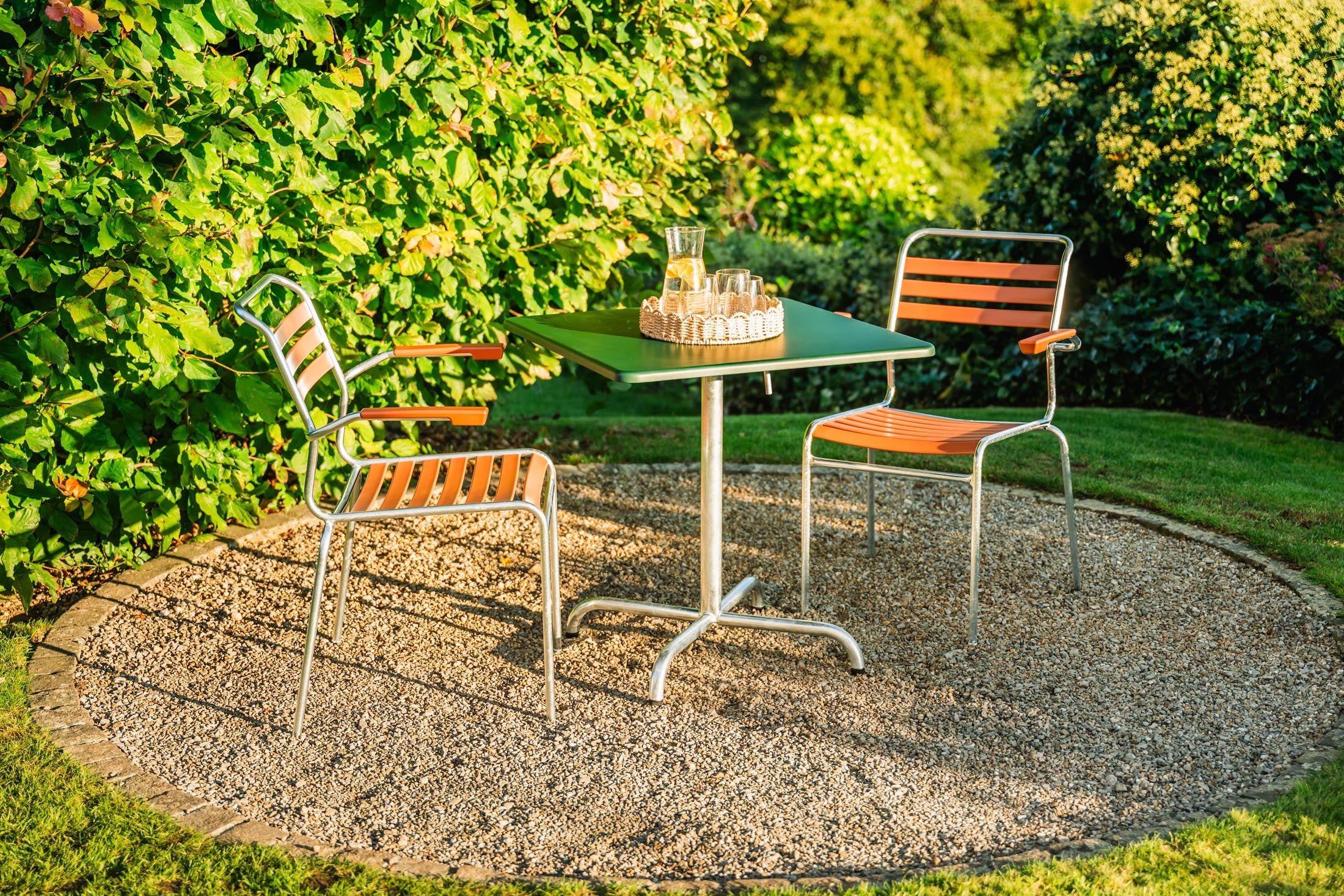 Säntis Lättli-Gartenstuhl mit Armlehne in Pastellterracotta präsentiert im Onlineshop von KAQTU Design AG. Gartenstuhl mit Armlehnen ist von Schaffner