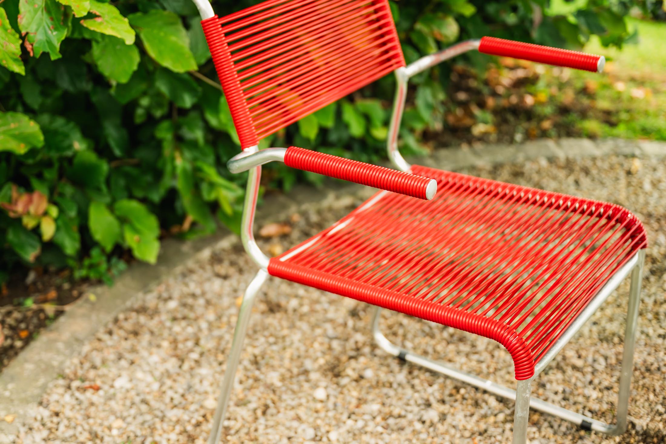 Eleganter Säntis Spaghetti-Gartenstuhl mit Armlehne, wetterfest, robust, nachhaltige Materialien, Schweizer Qualität, perfekt für Terrasse und Garten.