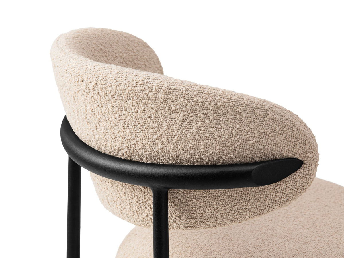 Zwei Bouclé-Stühle der Serie Nina in Beige mit Buchenholzgestell und schwarzen Stahlbeinen, gepolsterter Rückenlehne, freigestellt auf weissem Hintergrund.
