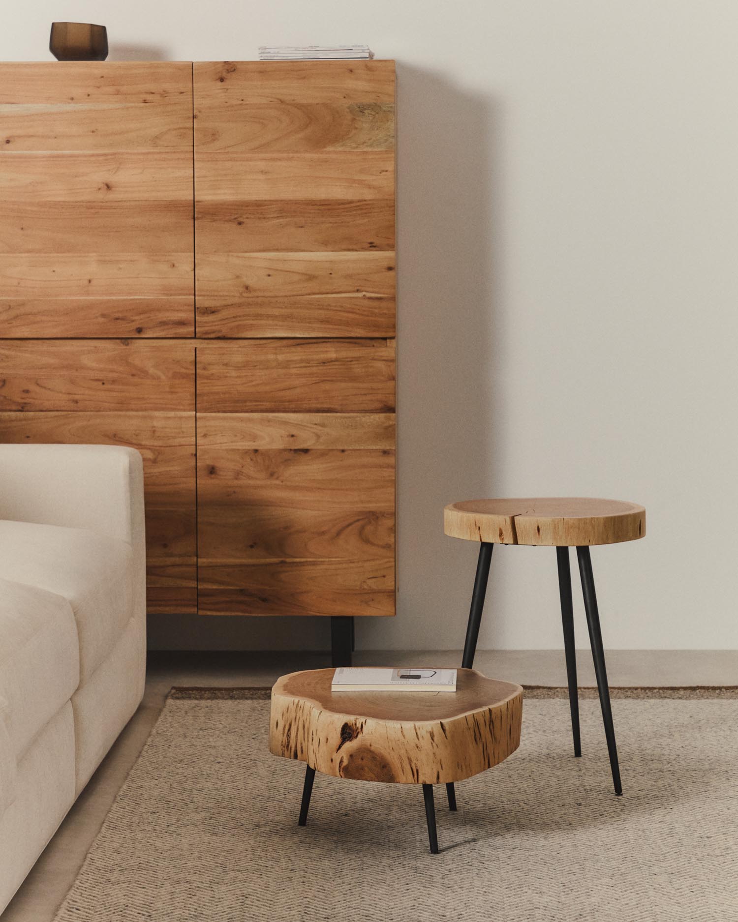 Couchtisch Tavine aus massivem Akazienholz mit gebleichtem Finish und schwarzen Stahlbeinen Ø 49 cm in Beige präsentiert im Onlineshop von KAQTU Design AG. Beistelltisch ist von Kave Home