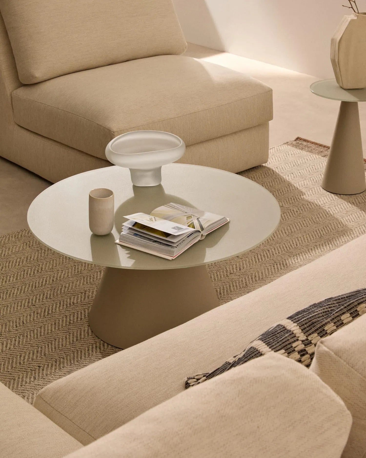 Moderner Couchtisch mit 80 cm Durchmesser, gehärtetem Glas und mattem Metallgestell in Grau.