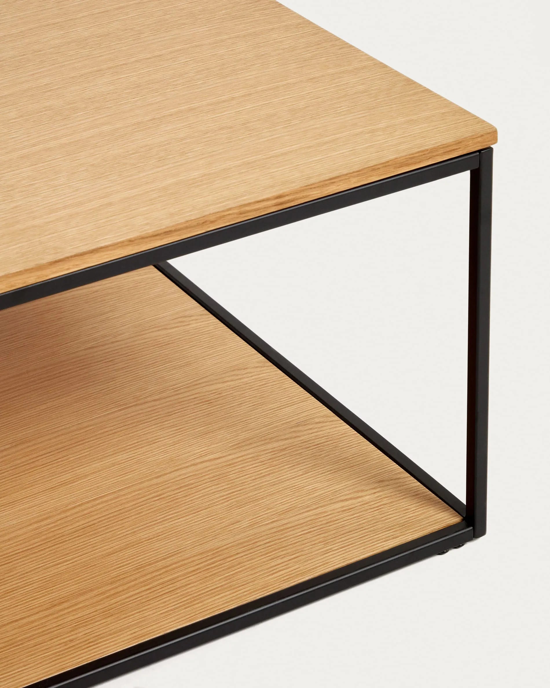 Der Yoana Couchtisch vereint Eichenfurnier und schwarzes Metall zu einem stilvollen, funktionalen Design für Ihr Wohnzimmer.