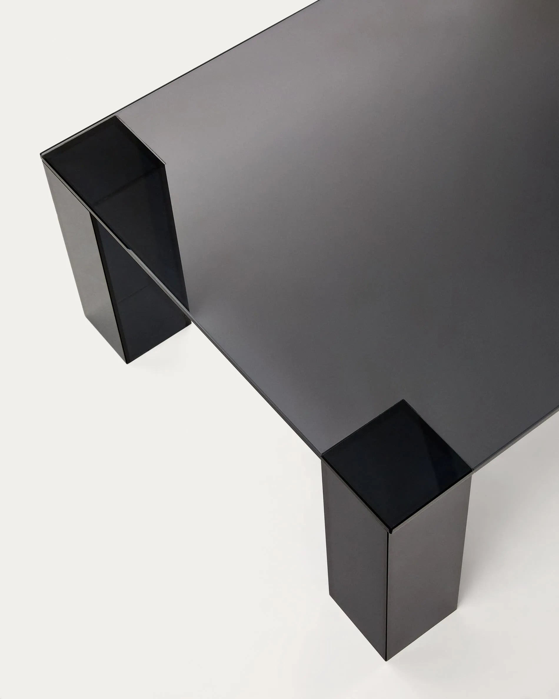 Eleganter Couchtisch aus dunkelgrauem Glas, 140x60 cm, vereint modernes Design mit Funktionalität und zeitloser Ästhetik.