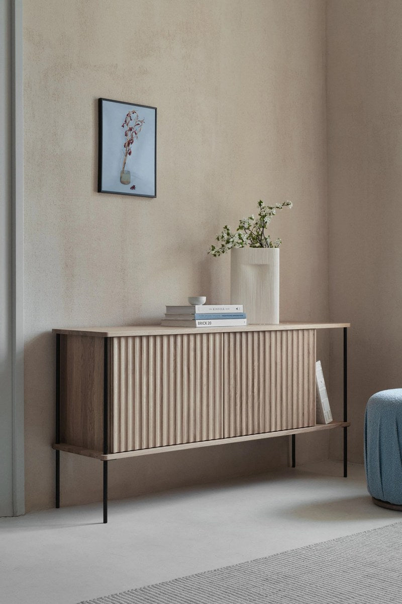 Sideboard Maya aus massivem Eichenholz mit gefräster Front, Push-to-Open-System und schlanken Stahlfüssen, Farbe Eiche Natur.