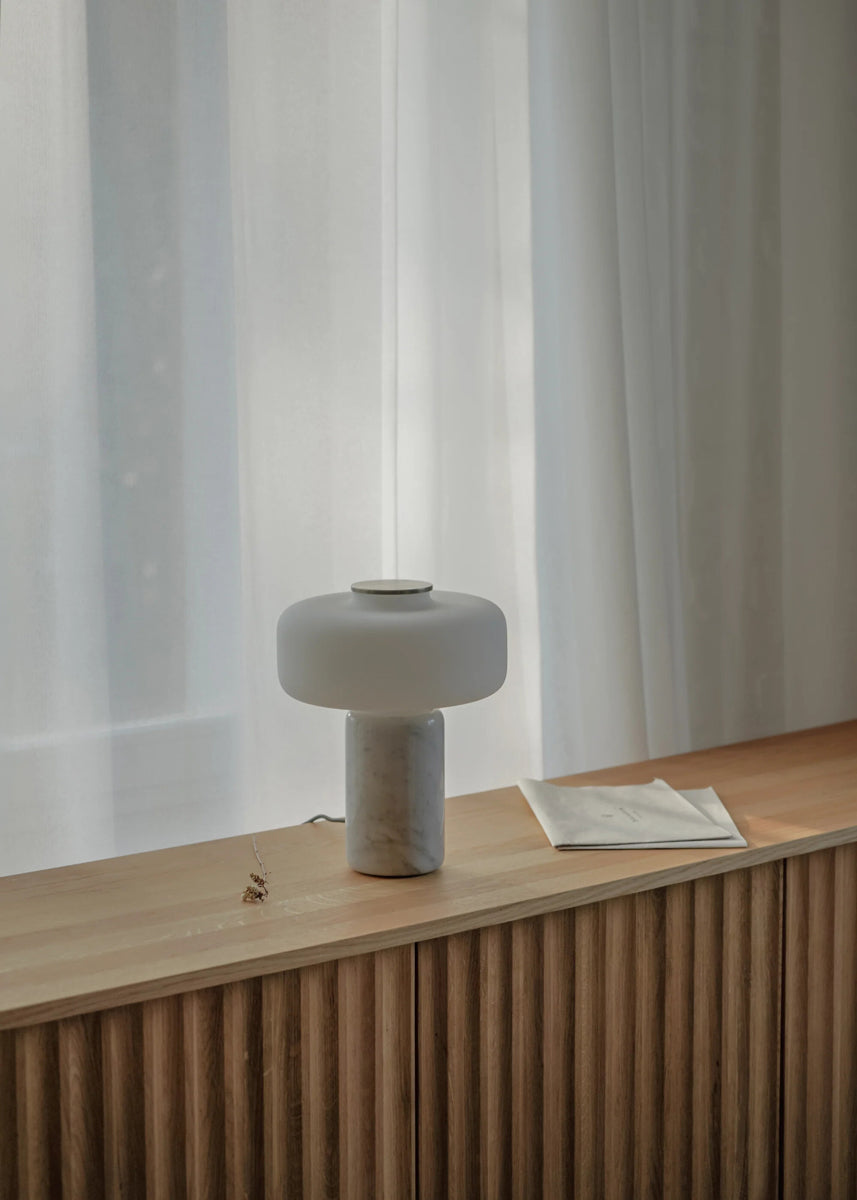 Elegante Fonte FNT01 Tischleuchte von Tamo, kombiniert zylindrischen Schirm mit stilvoller Basis, ideal für gemütliche Beleuchtung und modernes Ambiente.