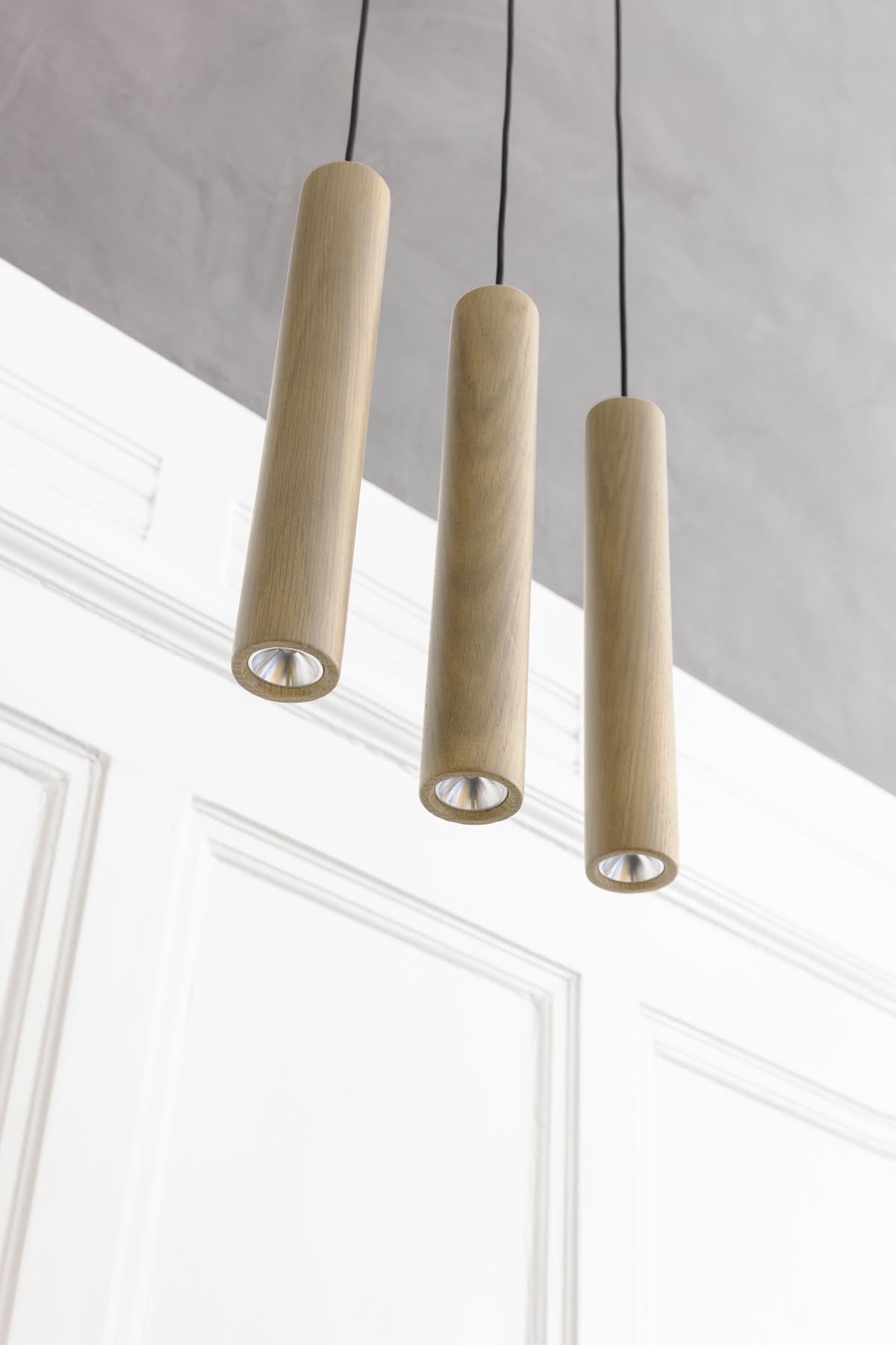 Stilvolle Chimes Pendellampe aus Eichenholz, die durch ihr modernes Design und sanfte Beleuchtung eine gemütliche Atmosphäre schafft.