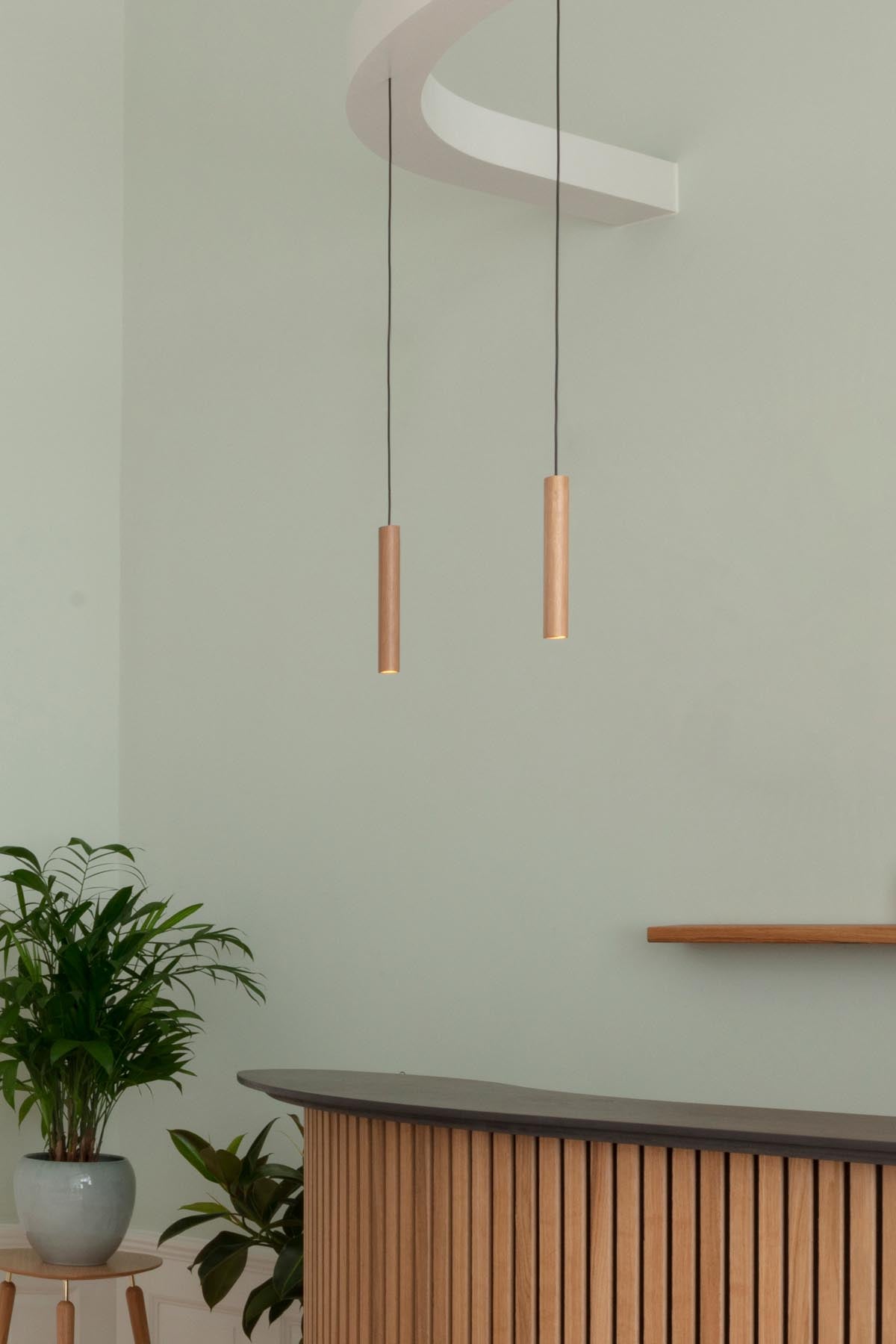 Moderne Chimes Pendellampe aus Eichenholz, die durch ihr zeitloses Design und sanfte Beleuchtung eine gemütliche Atmosphäre schafft.