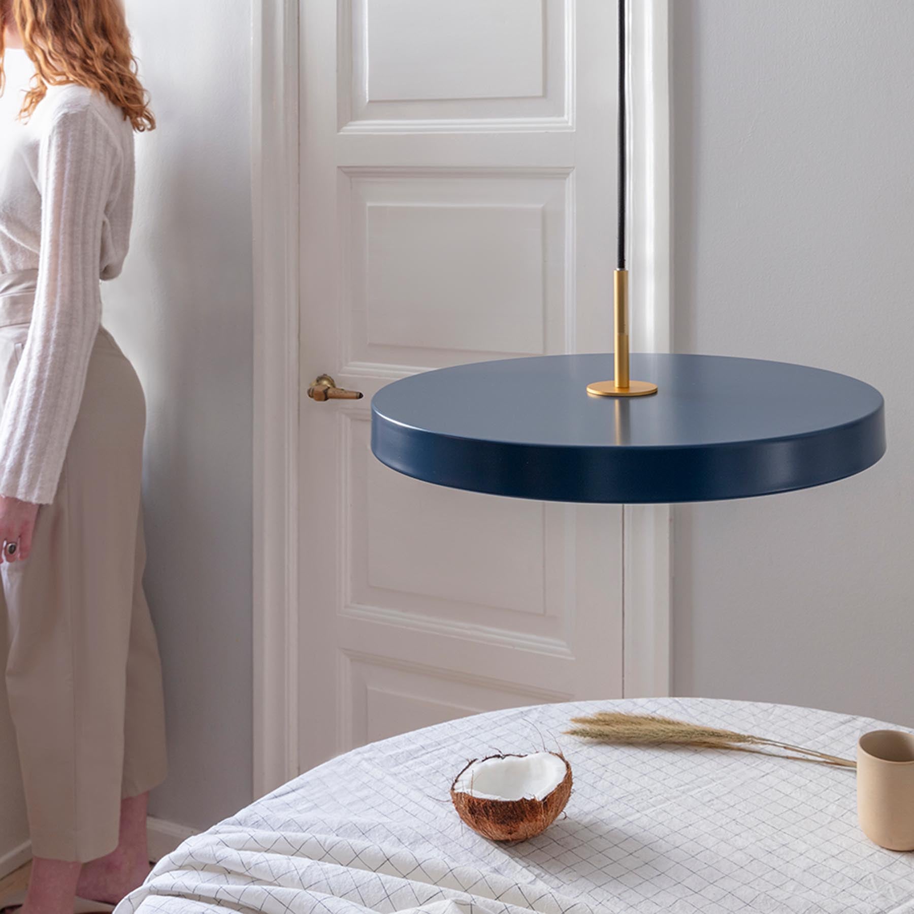 Elegante Asteria Medium Pendellampe in Petrol Blue, stilvoll inszeniert, ideal für moderne Wohnräume und kreative Lichtgestaltung.