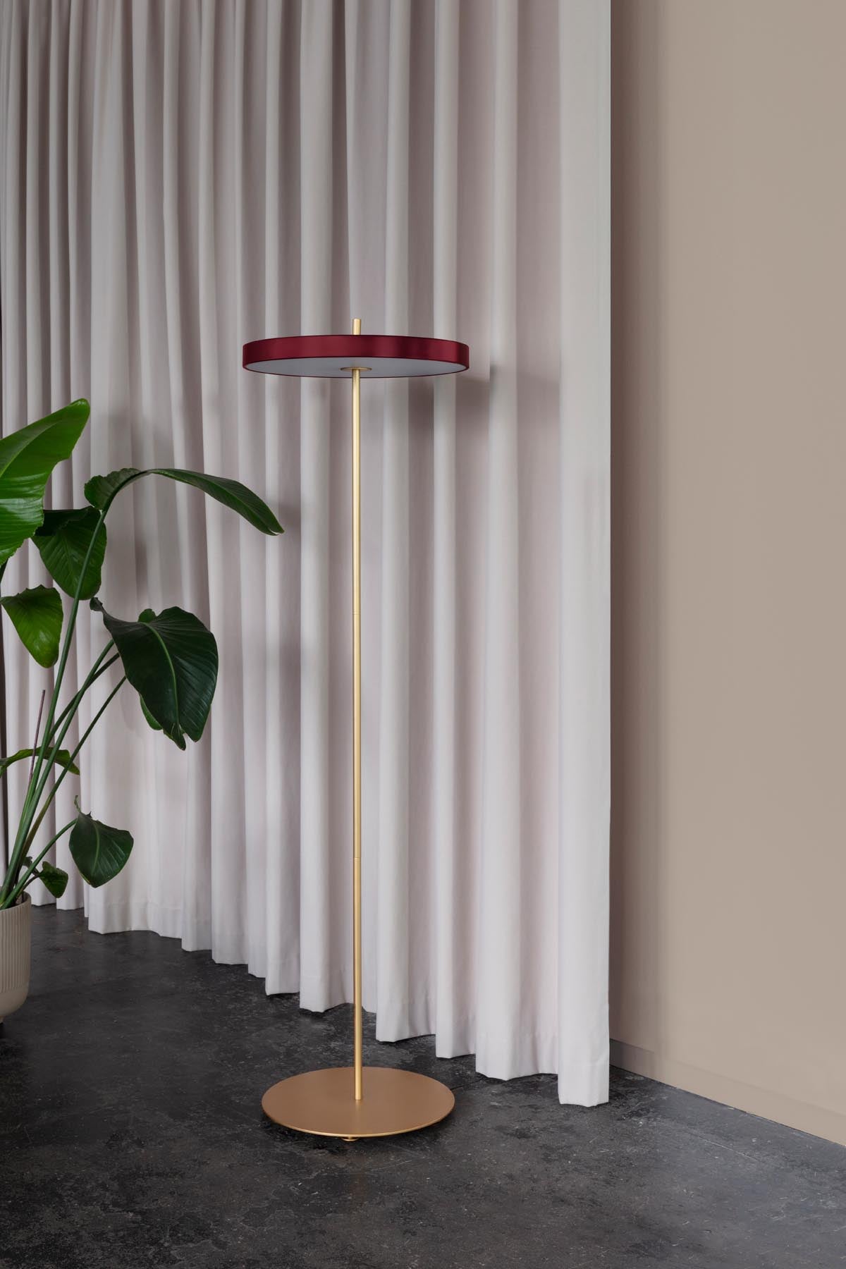 Elegante Asteria Stehleuchte in Ruby Red, stilvoll inszeniert, ideal für moderne Wohnräume und stimmungsvolle Beleuchtung.