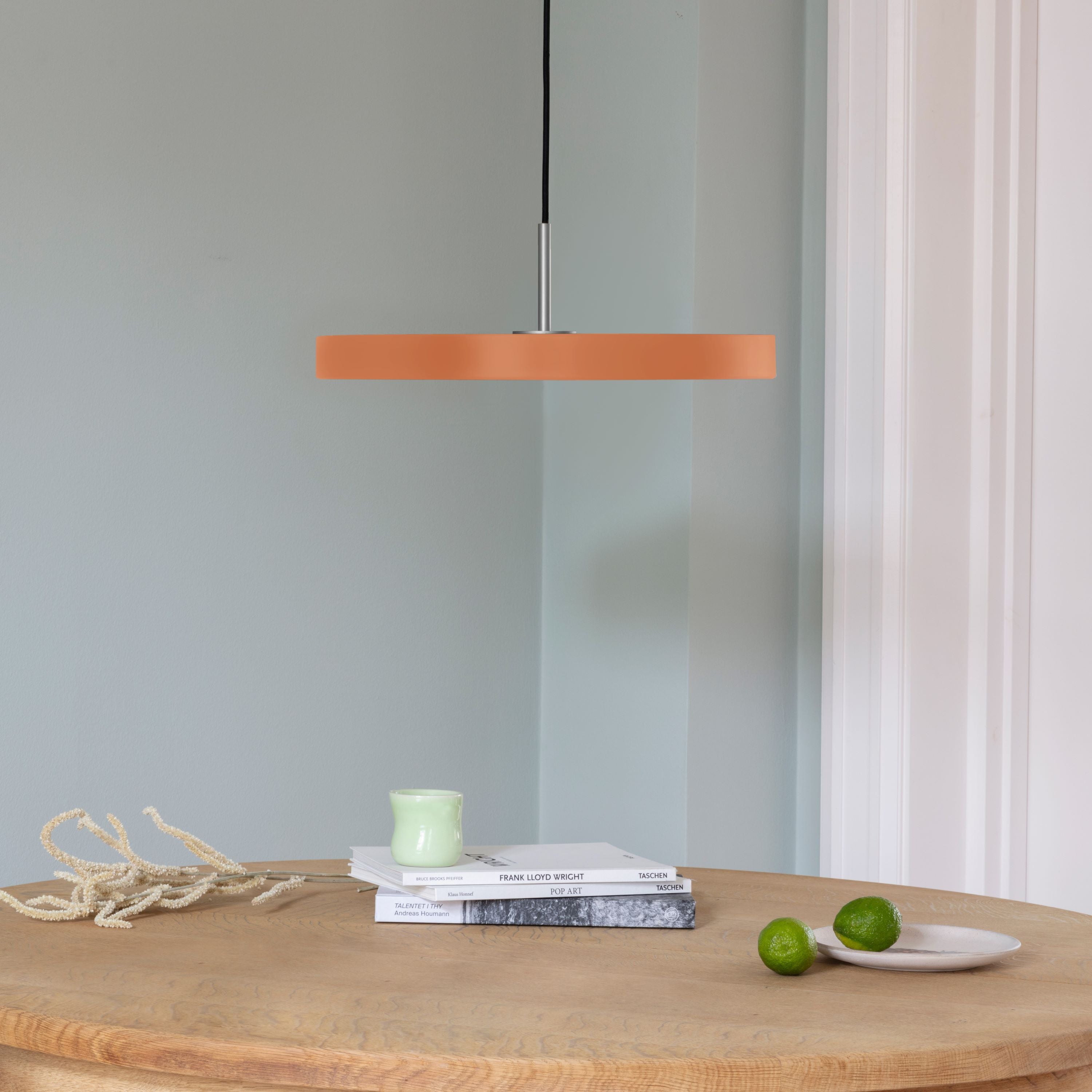 Elegante Asteria Medium Pendellampe von Umage in warmen Orangetönen, ideal für stimmungsvolle Beleuchtung und modernes Interieur.