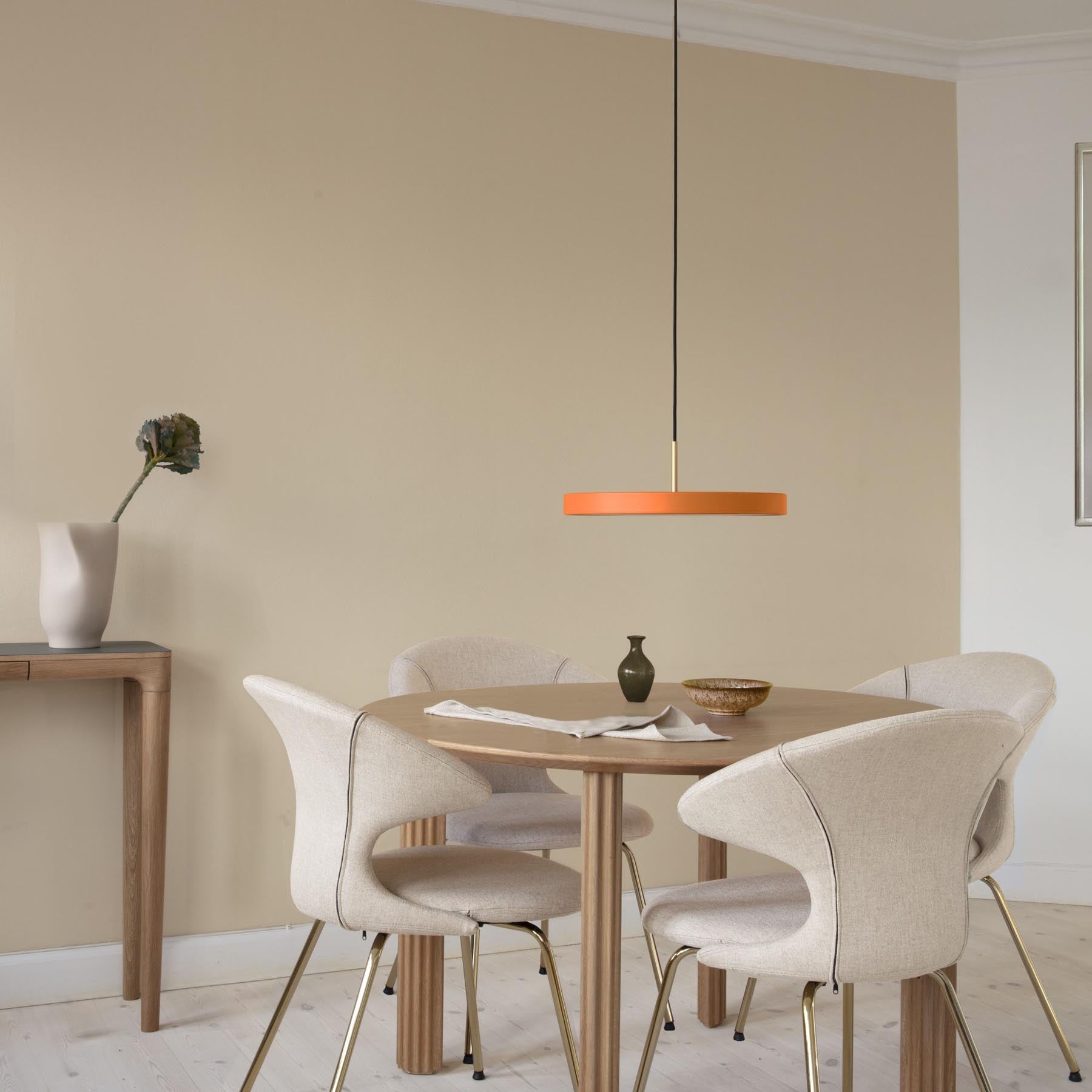 Elegante Asteria Medium Pendellampe in warmem Orange, ideal für stimmungsvolle Beleuchtung in modernen Wohnräumen.