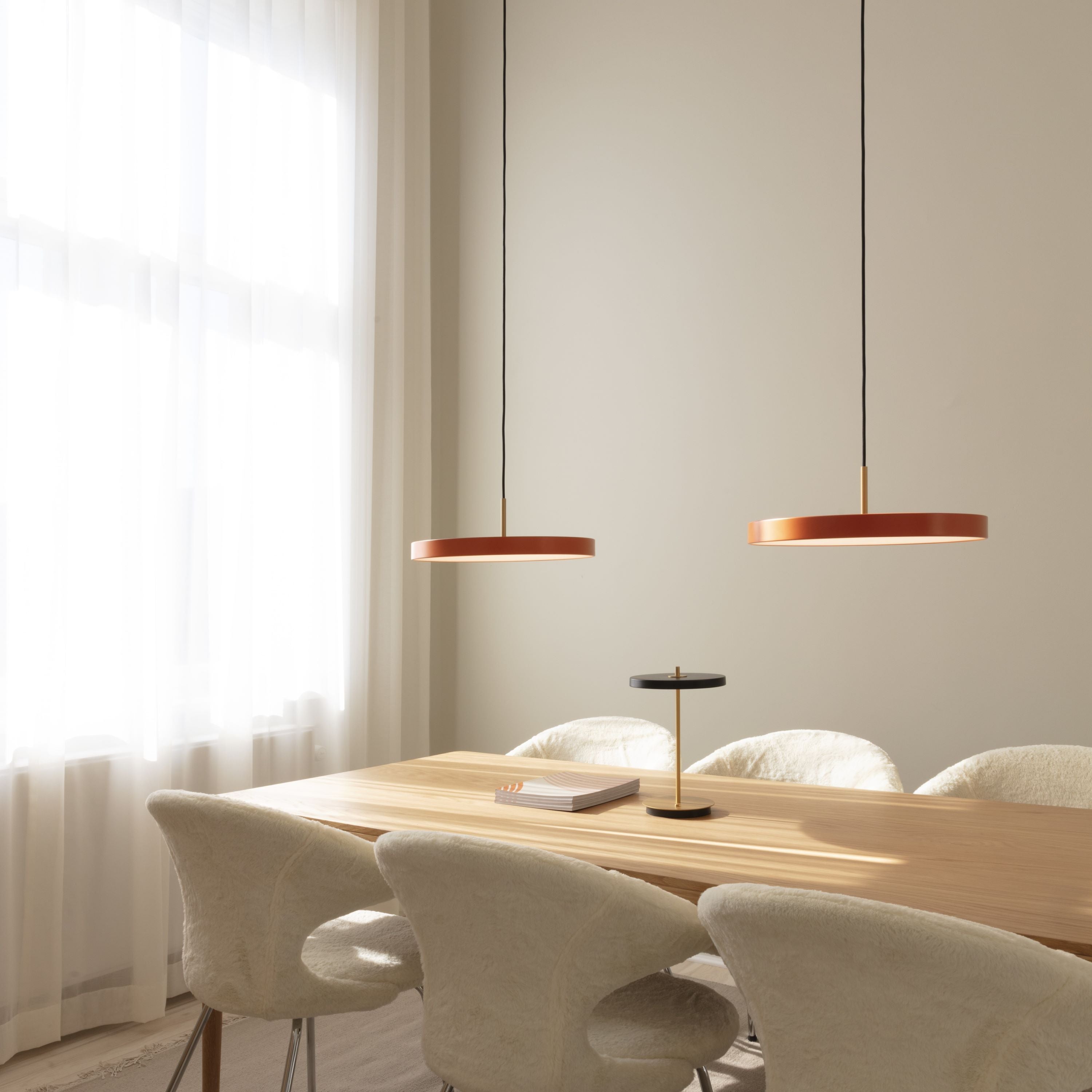 Stilvolle Asteria Medium Pendellampe von Umage in sanften Orangetönen, perfekt für eine gemütliche Atmosphäre und zeitgemäße Einrichtung.