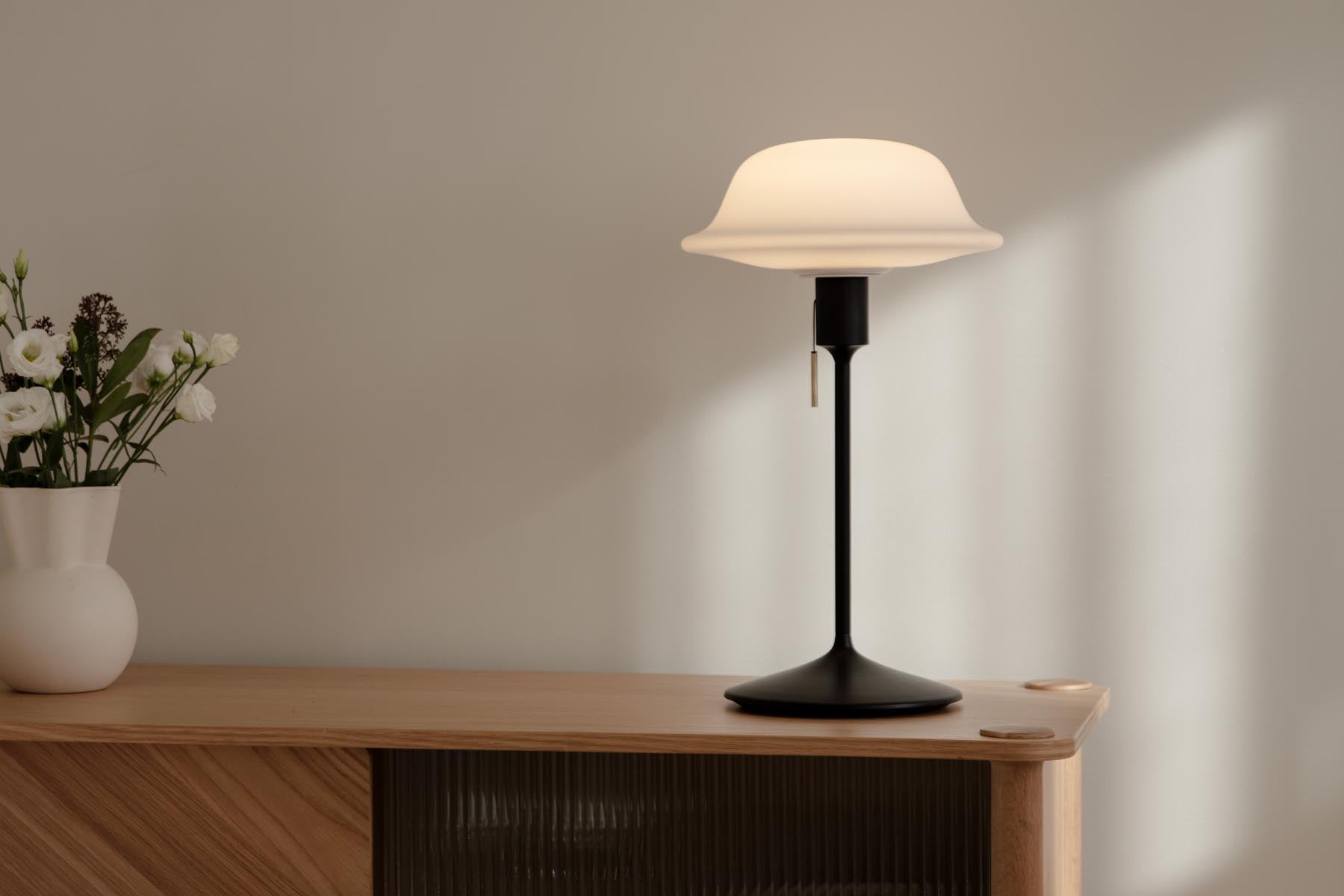 Elegante Butler Tisch- und Stehleuchte von Umage, ideal für stimmungsvolle Beleuchtung in modernen Wohnräumen.