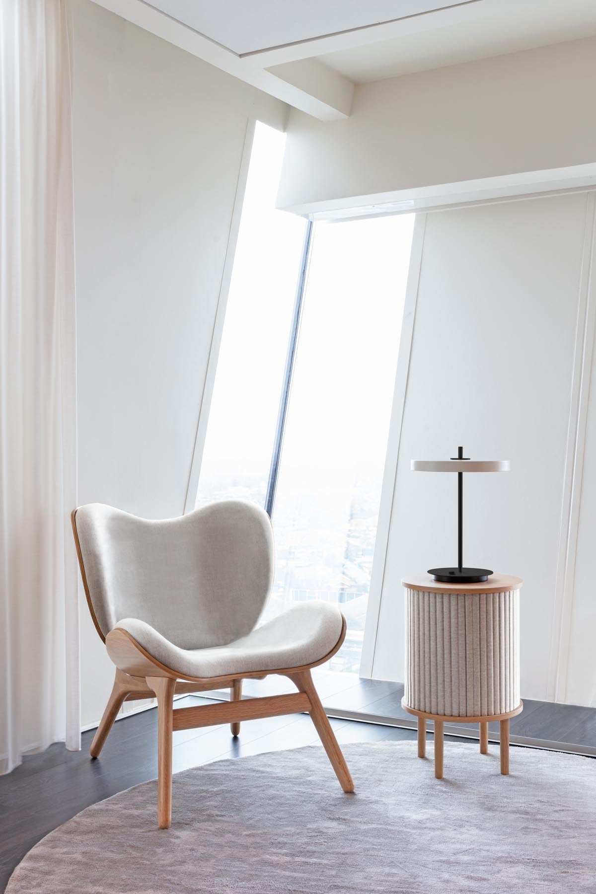 Moderne Asteria Tischleuchte in sanftem Pearl White, kombiniert mit einem eleganten schwarzen Fuß, perfekt für eine stilvolle Raumgestaltung.