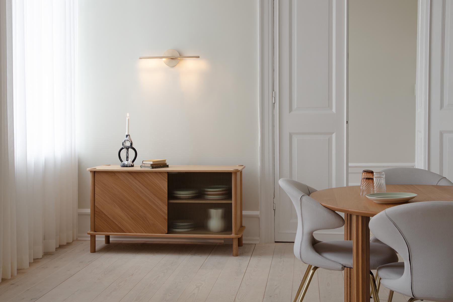 Elegante Omni Wall Wandleuchte von Umage, die mit ihrem minimalistischen Look und warmem Licht eine gemütliche Atmosphäre schafft.