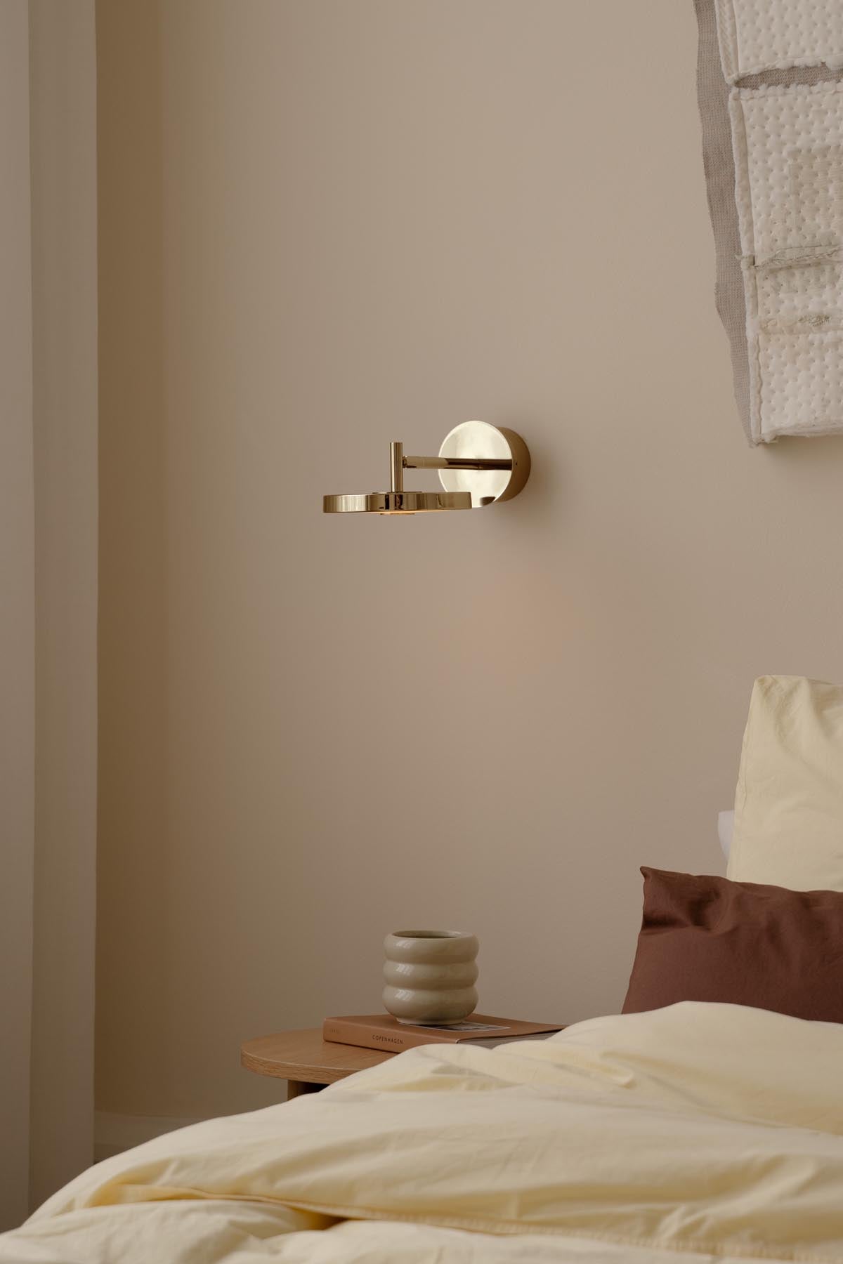 Moderne Asteria Wandleuchte short Hardwired von Umage, gefertigt aus hochwertigem Messing, perfekt für eine stilvolle Raumgestaltung.