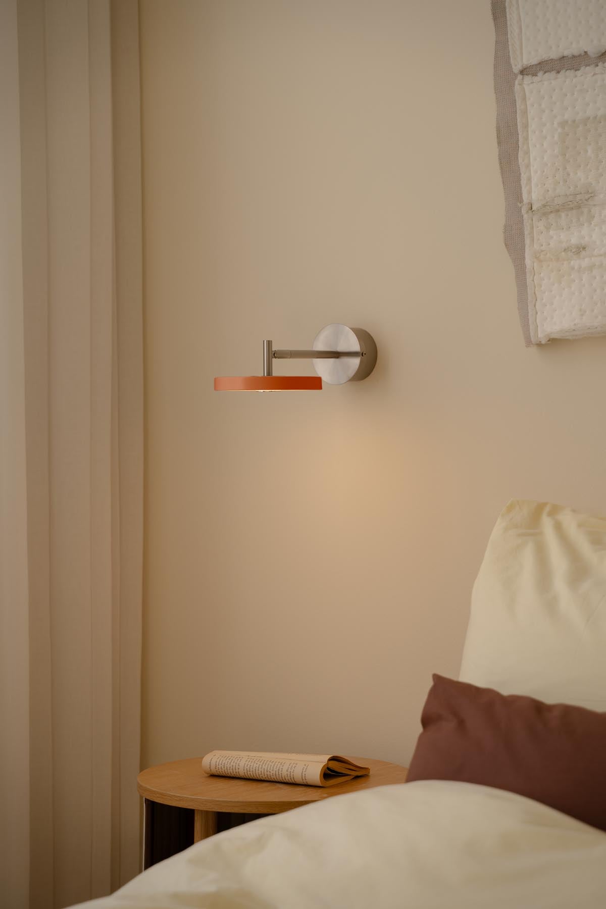 Moderne Asteria Wandleuchte short Hardwired in sanftem Orange, perfekt für stilvolle Beleuchtung und gemütliche Atmosphäre.