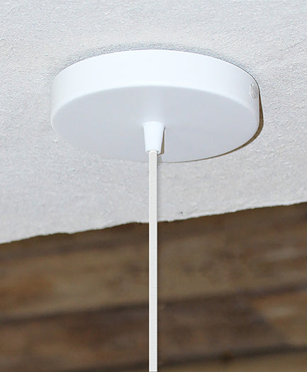 Elegante Rosette in Weiß von Umage, ideal für stilvolle Kabel- und Lampenfassungen, präsentiert in einem modernen Wohnambiente.