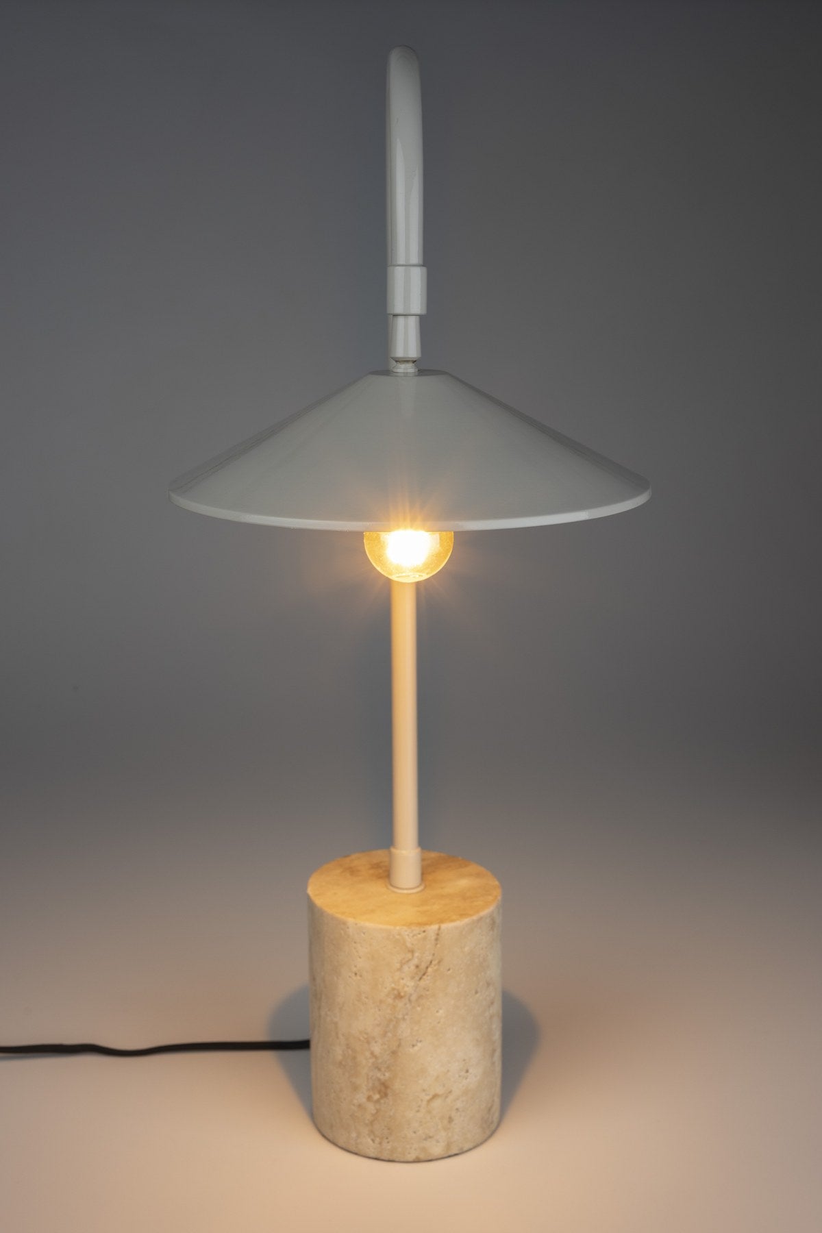 Graue Tischleuchte Desk Lamp Enno mit zylindrischem Travertin-Fuss, Bogen und Lampenschirm aus Eisen sowie schwarzem Kabel, Modell von White Label Living.