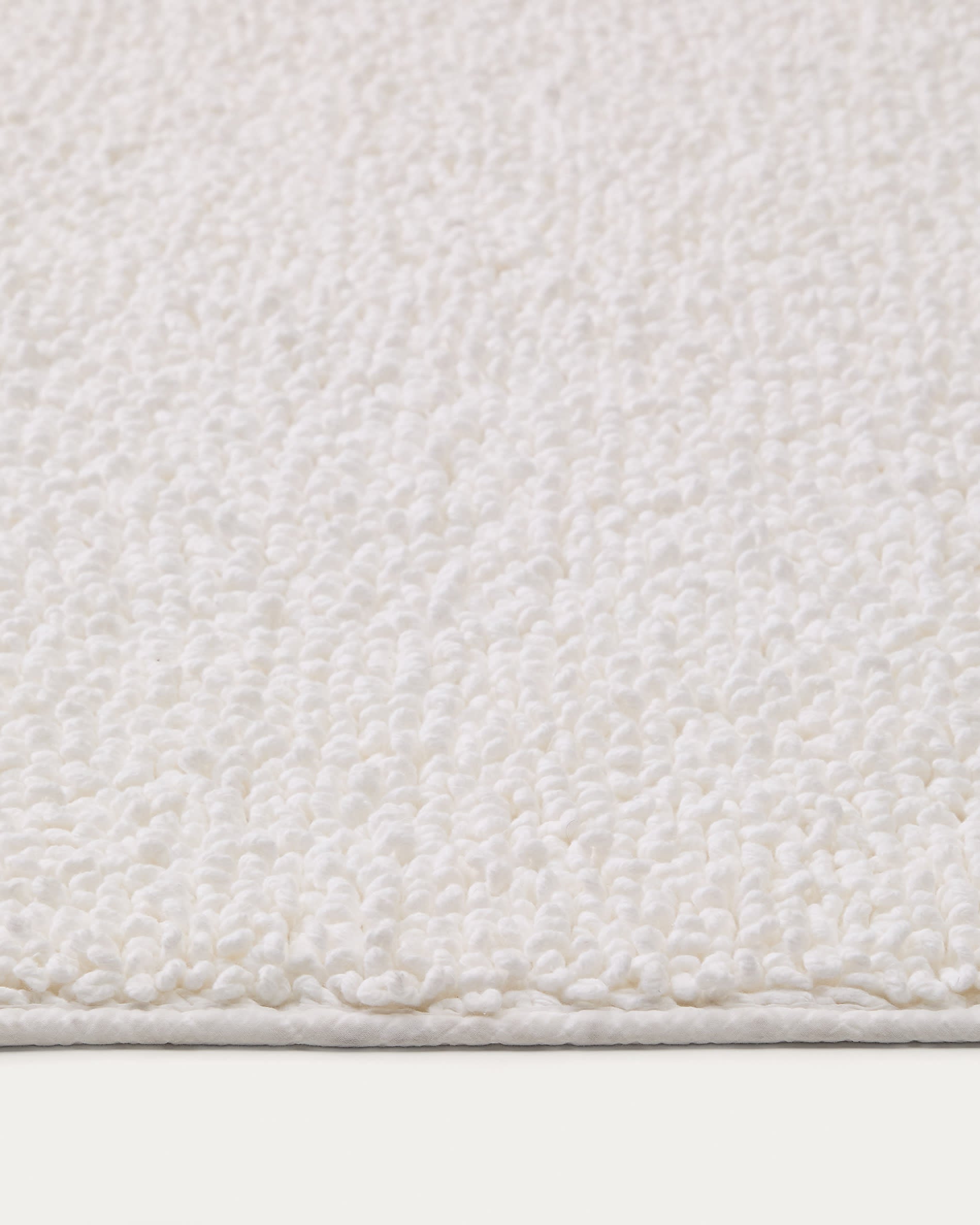 Die weiße Badematte Uvite (50x70 cm) aus 100% Baumwolle von Kave Home vereint Komfort, Qualität und modernes Design für Ihr Bad.
