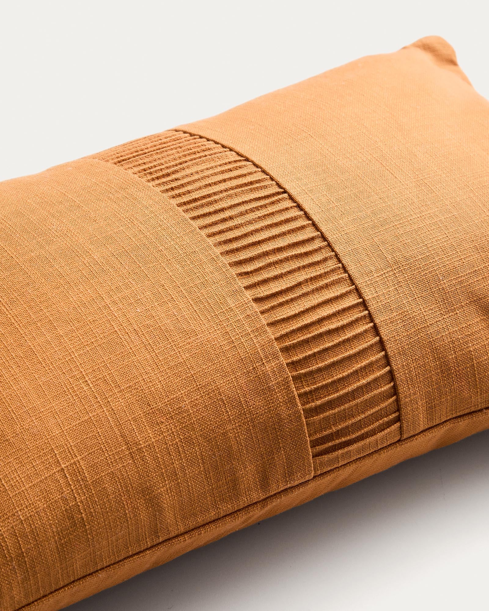 Stylischer Kissenbezug Luadia in leuchtendem Orange, aus hochwertiger Baumwolle mit elegantem Plisseedetail, ideal für moderne Wohnräume.